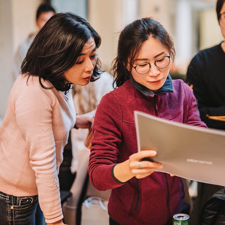 A few Framework employees closely examining a document together during a work discussion.