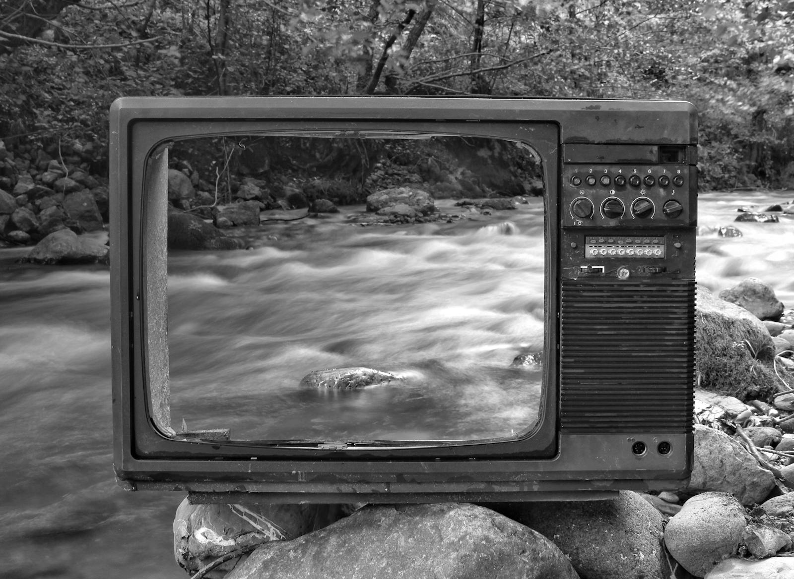 An empty TV screen in front of a creek