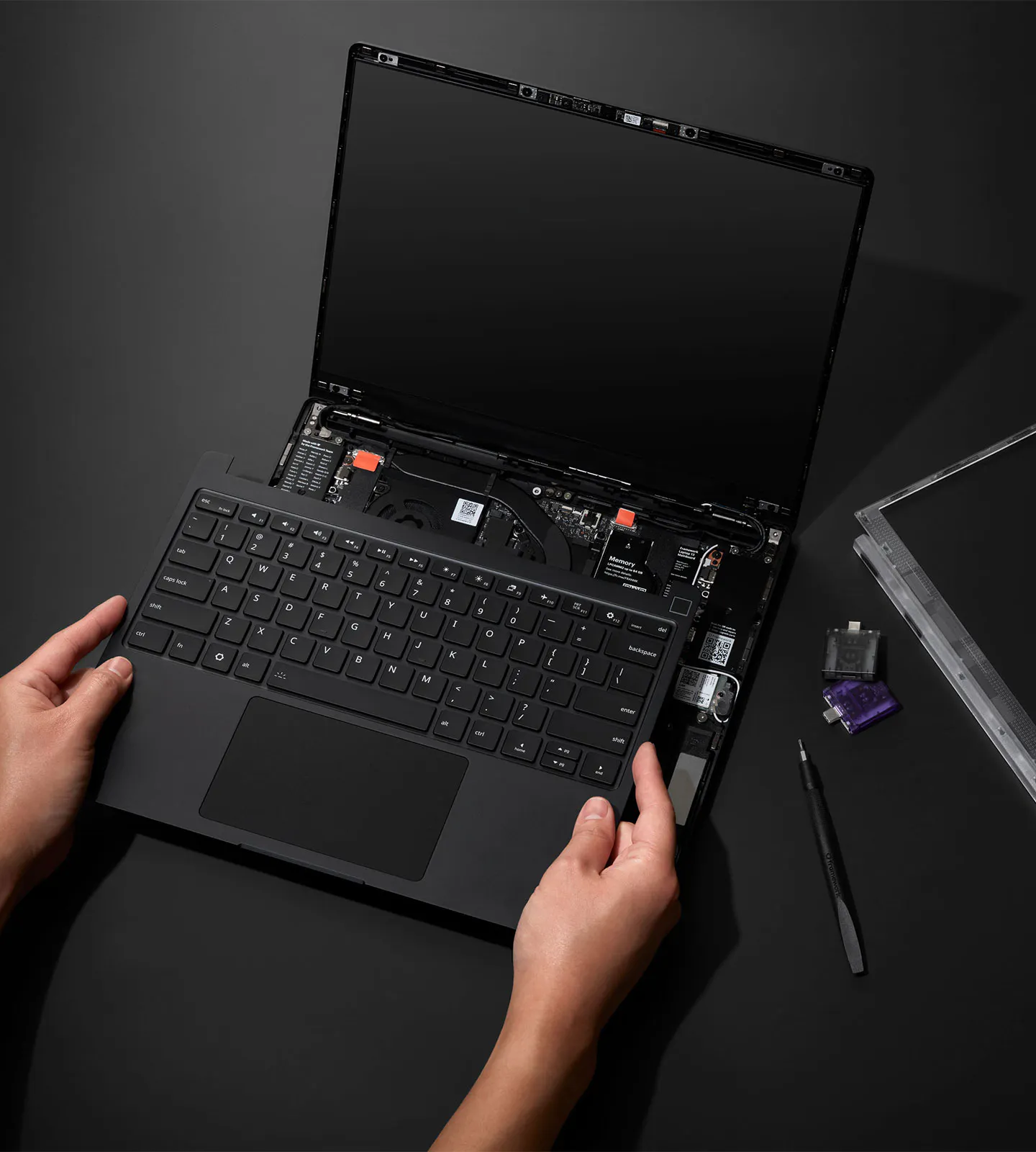 A top-down installation shot of a Laptop 13 Pro placed on a deep gray surface.