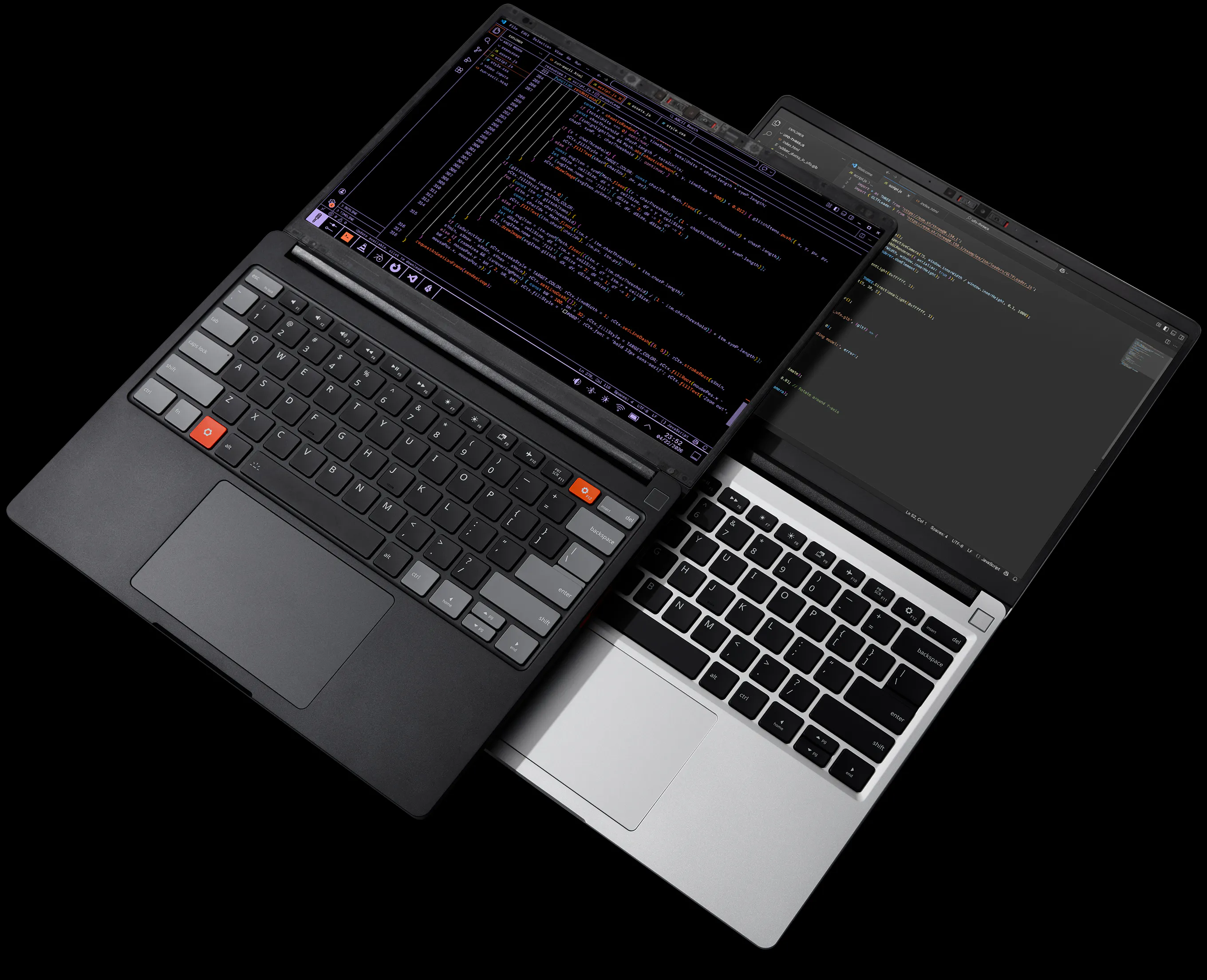 A top-down, high-contrast photograph against a black background featuring two Framework Laptops overlapping diagonally. One laptop is Framework Laptop 13 Pro Graphite, and the other is the Framerwork Laptop 13 Silver.