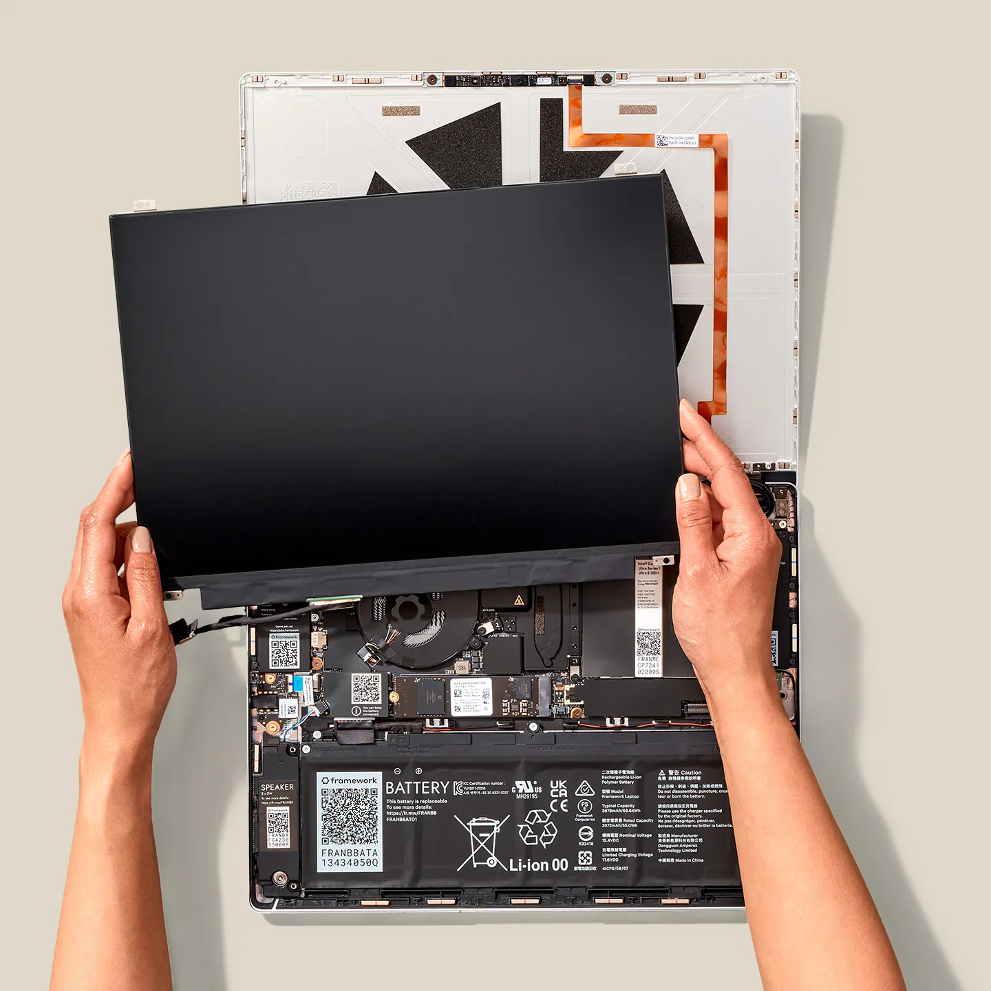 A top-down studio shot of a Framework Laptop 13 showing display installation.