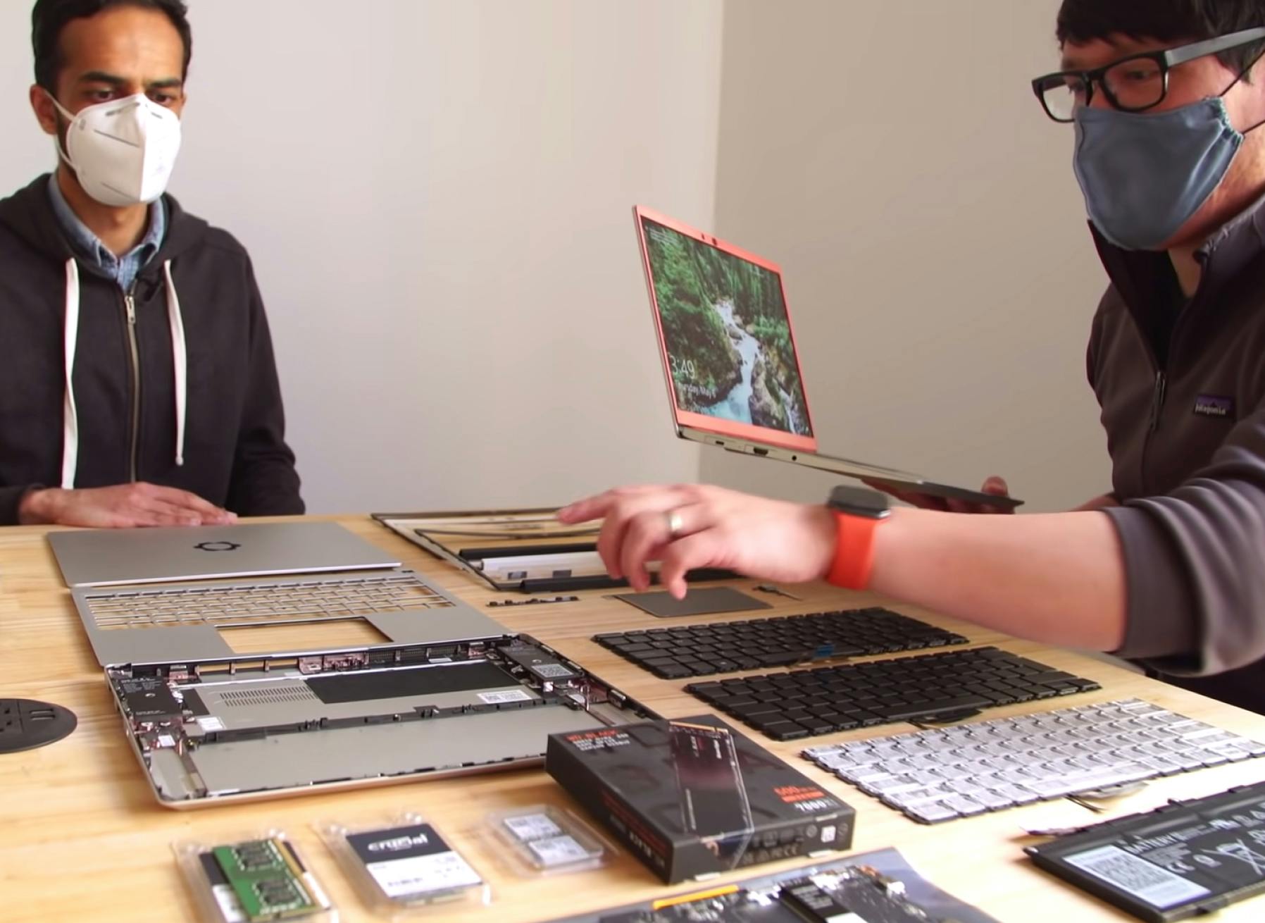 Two people gathered around a table of Framework Laptop parts