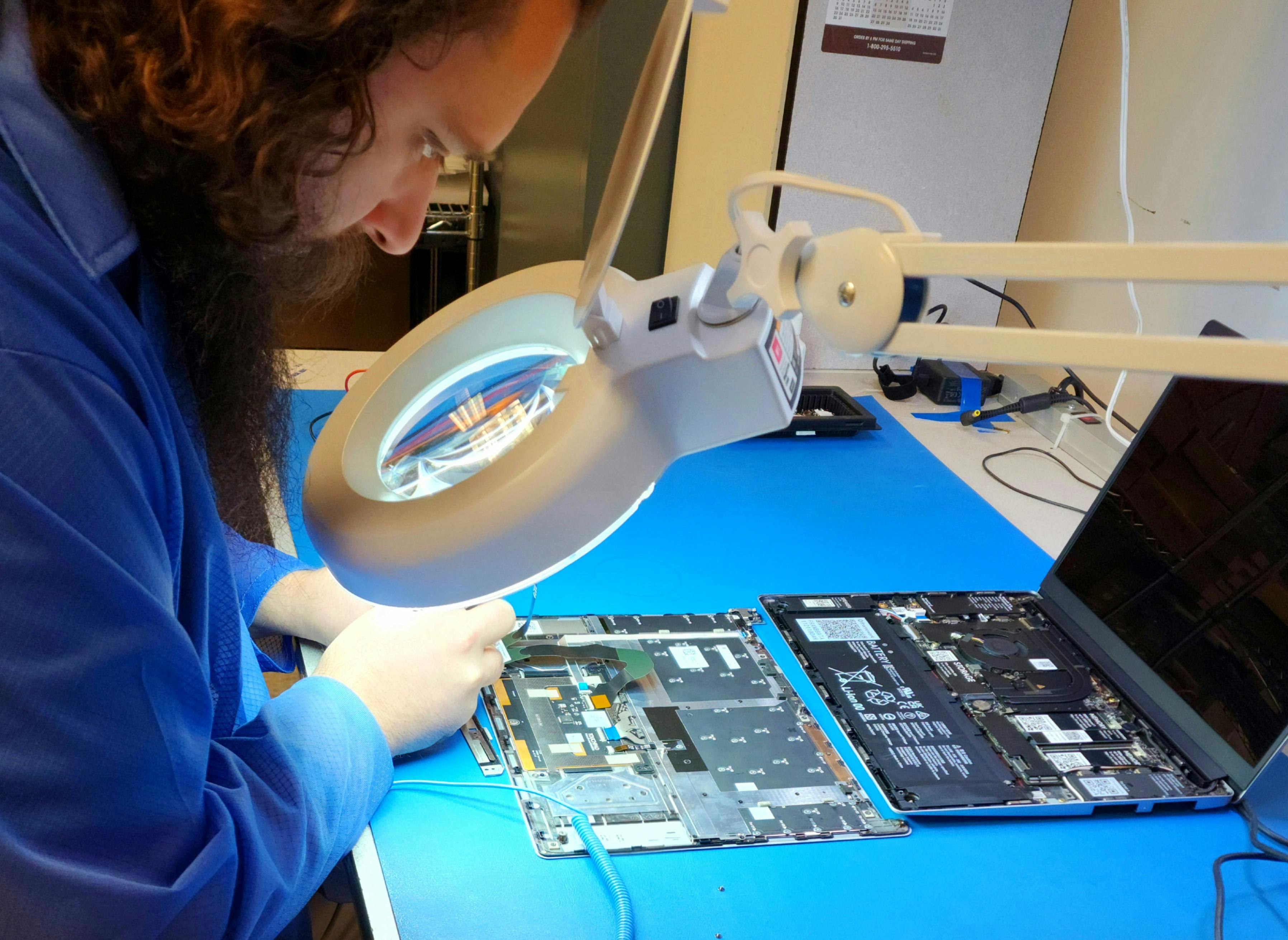 A technician testing a disassembled refurbished Framework Laptop
