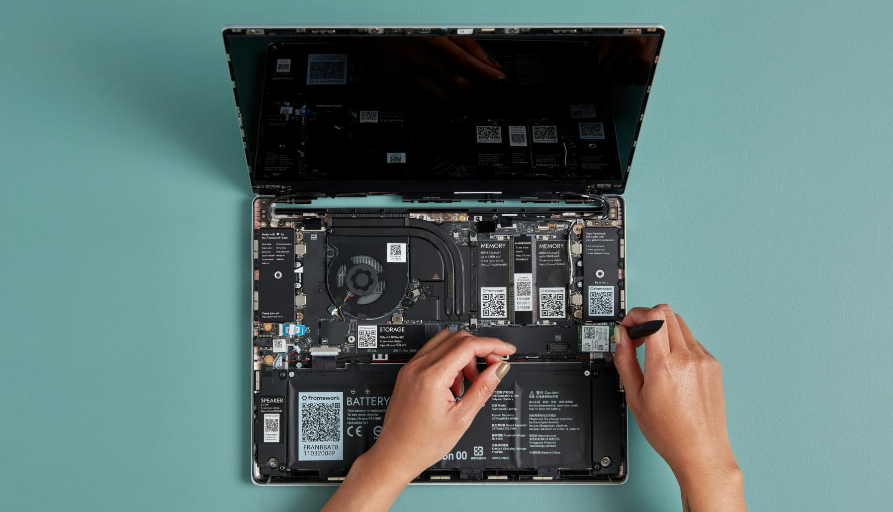Topdown view of Laptop internals with someone removing the WiFi module