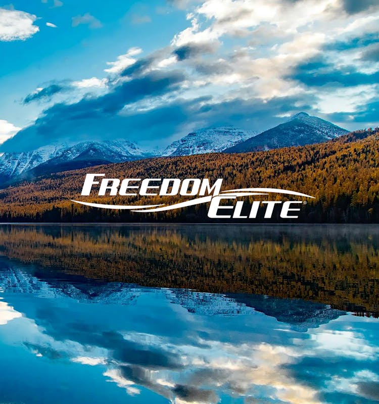 Freedom Elite logo with beautiful mountains and lake view