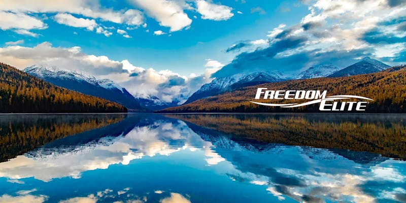 Freedom Elite logo with beautiful mountains and lake view