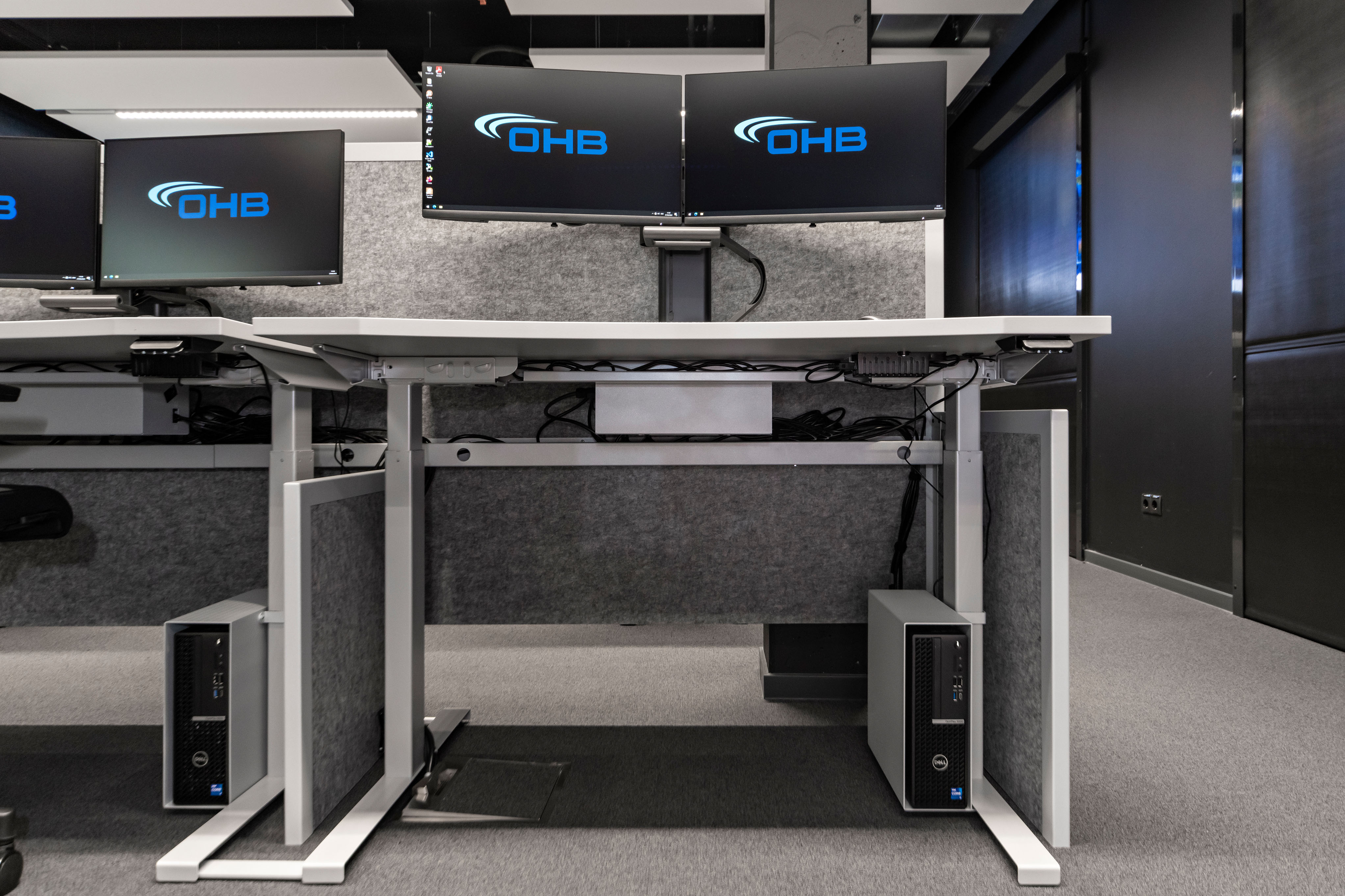 OHB Digital Connect GmbH I lino Schreibtisch, elektrisch höhenverstellbar | Tischanschlußfelder in Sonderausführung | gepulverte Tischplatten in Sonderform | Akustikblenden & Sichtschutz aus Polyestervlies | sano Drehstuhl