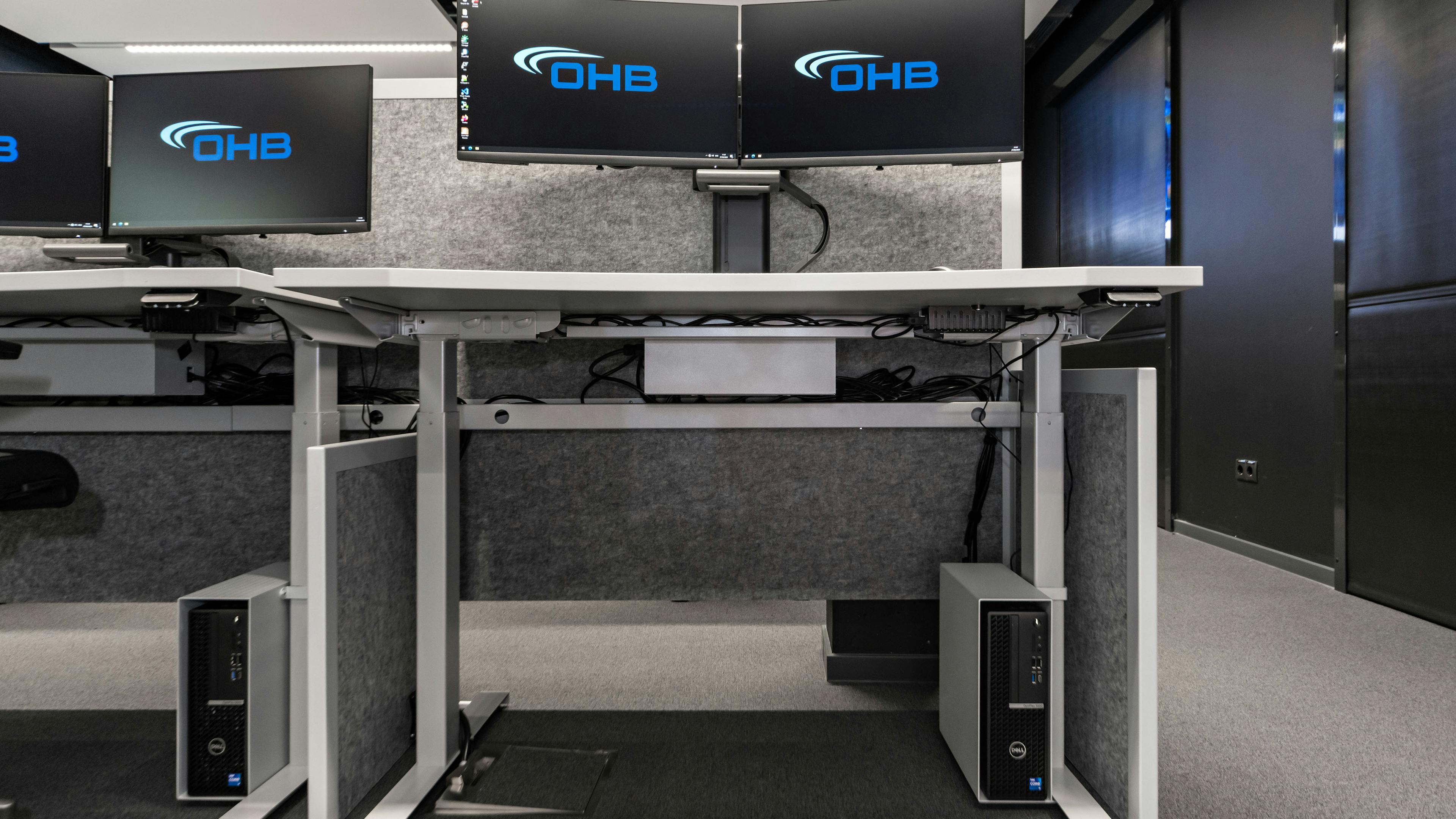 OHB Digital Connect GmbH I lino Schreibtisch, elektrisch höhenverstellbar | Tischanschlußfelder in Sonderausführung | gepulverte Tischplatten in Sonderform | Akustikblenden & Sichtschutz aus Polyestervlies | sano Drehstuhl