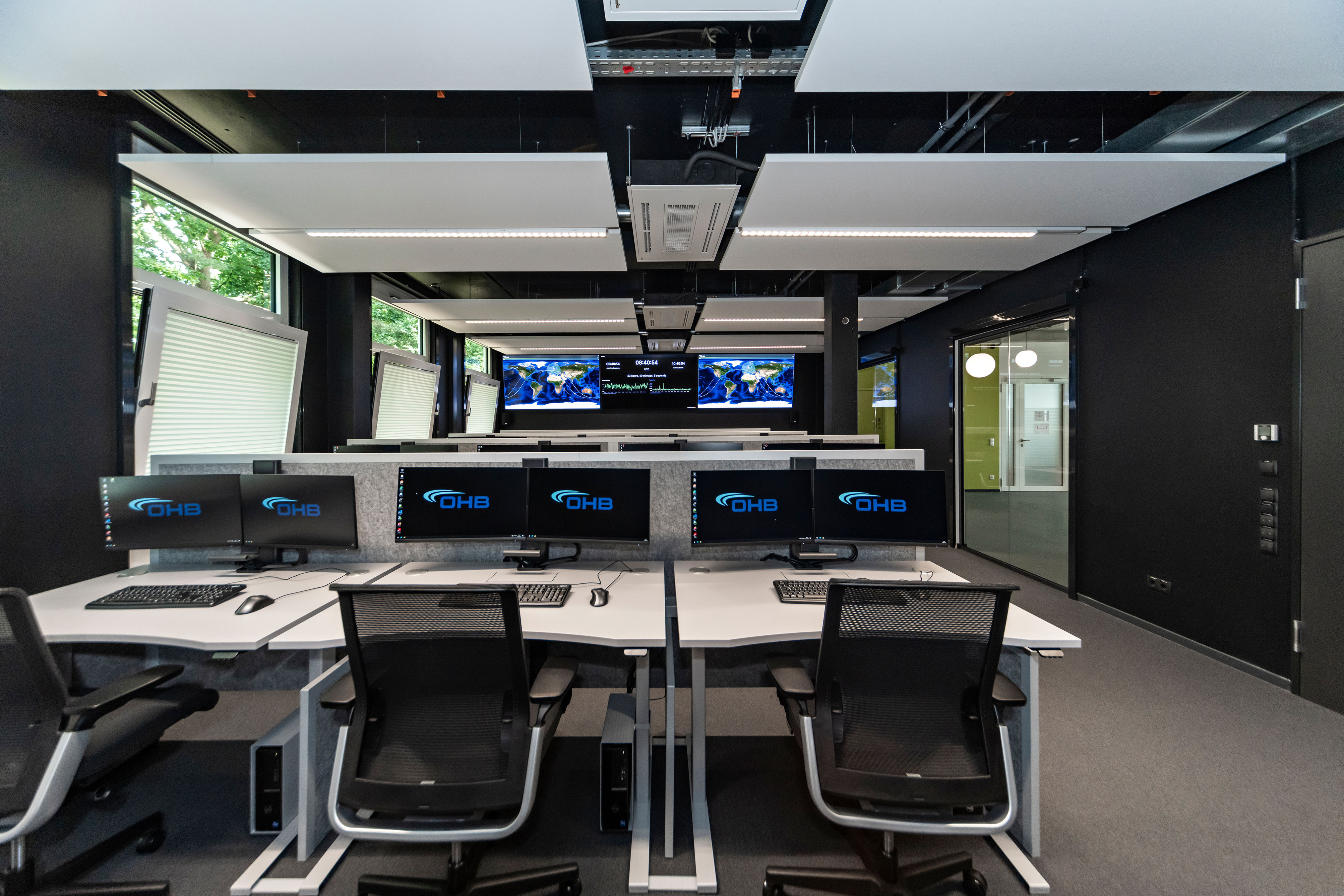 OHB Digital Connect GmbH I lino Schreibtisch, elektrisch höhenverstellbar | Tischanschlußfelder in Sonderausführung | gepulverte Tischplatten in Sonderform | Akustikblenden & Sichtschutz aus Polyestervlies | sano Drehstuhl