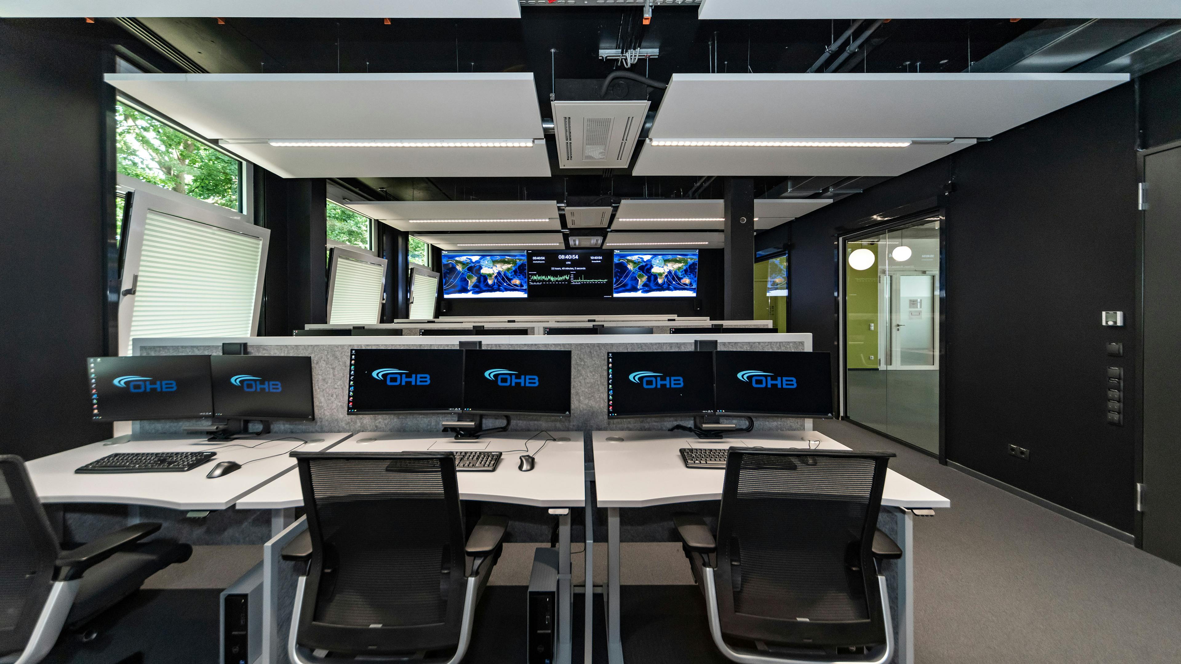 OHB Digital Connect GmbH I lino Schreibtisch, elektrisch höhenverstellbar | Tischanschlußfelder in Sonderausführung | gepulverte Tischplatten in Sonderform | Akustikblenden & Sichtschutz aus Polyestervlies | sano Drehstuhl