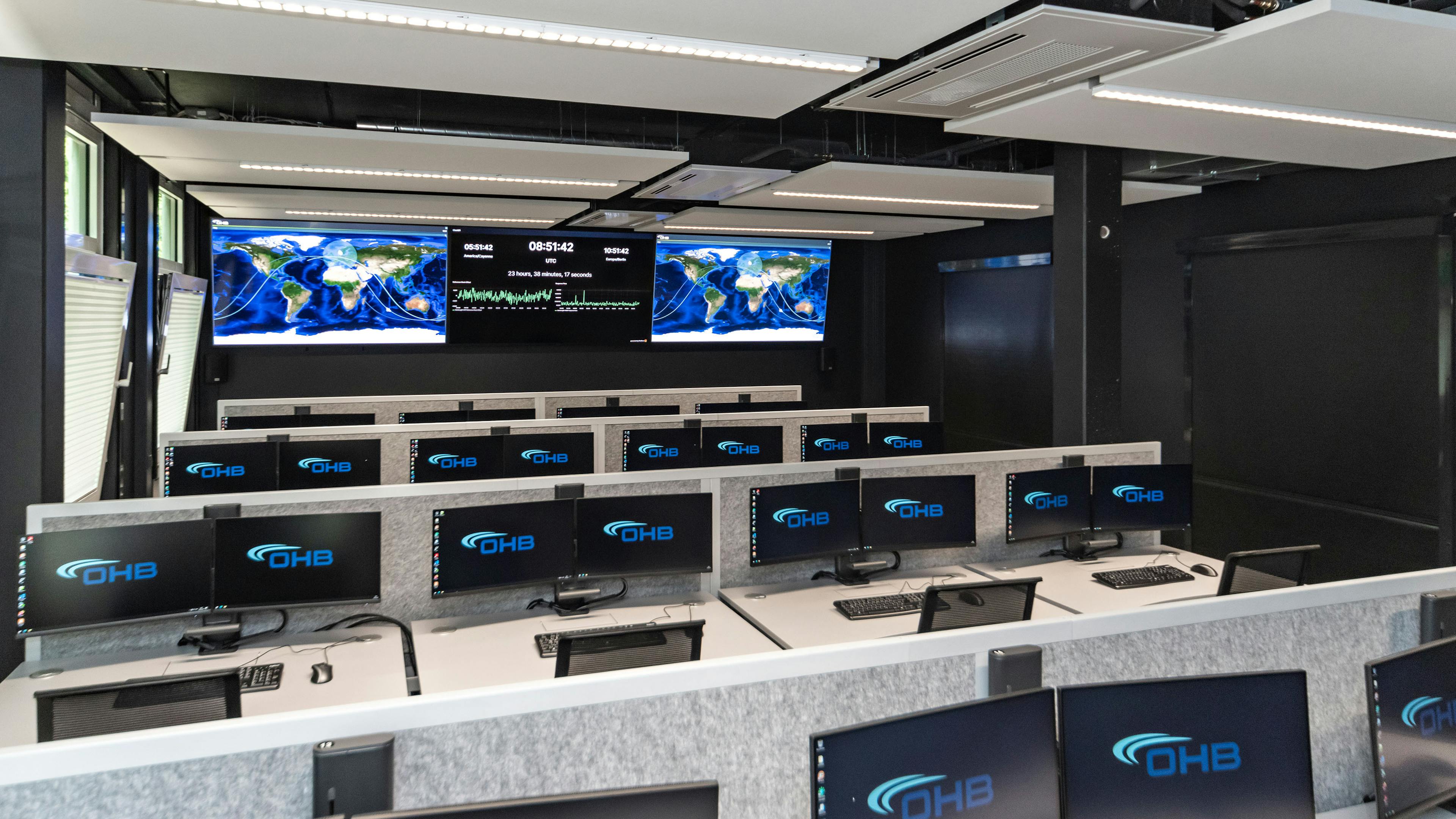 OHB Digital Connect GmbH I lino Schreibtisch, elektrisch höhenverstellbar | Tischanschlußfelder in Sonderausführung | gepulverte Tischplatten in Sonderform | Akustikblenden & Sichtschutz aus Polyestervlies | sano Drehstuhl