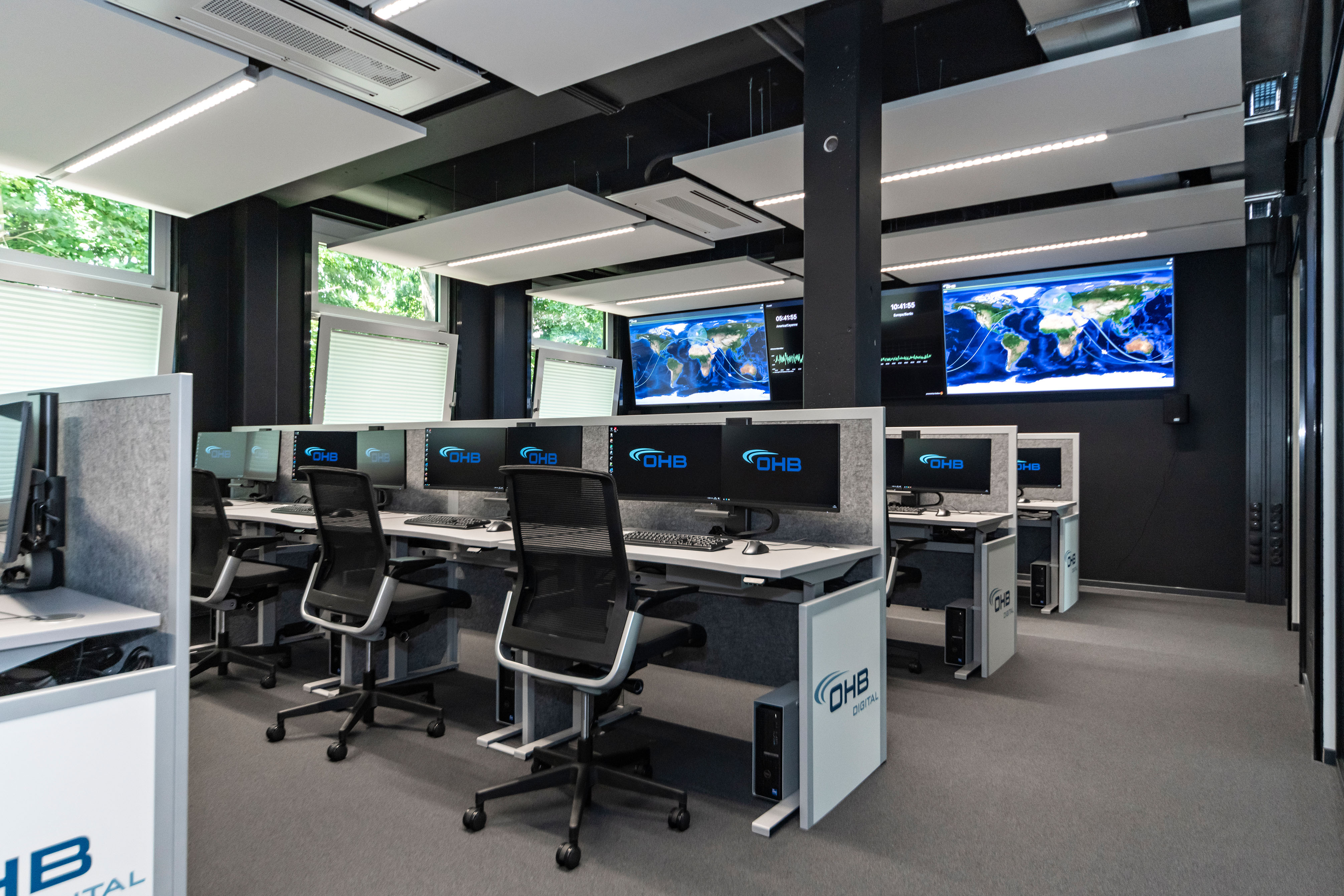 OHB Digital Connect GmbH I lino Schreibtisch, elektrisch höhenverstellbar | Tischanschlußfelder in Sonderausführung | gepulverte Tischplatten in Sonderform | Akustikblenden & Sichtschutz aus Polyestervlies | sano Drehstuhl