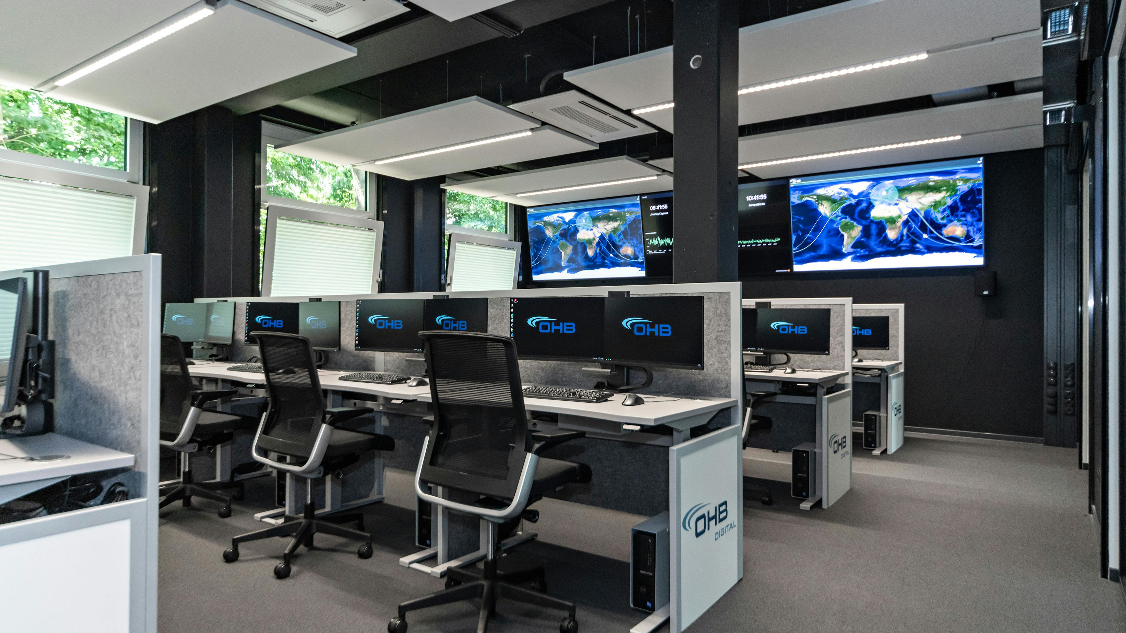 OHB Digital Connect GmbH I lino Schreibtisch, elektrisch höhenverstellbar | Tischanschlußfelder in Sonderausführung | gepulverte Tischplatten in Sonderform | Akustikblenden & Sichtschutz aus Polyestervlies | sano Drehstuhl