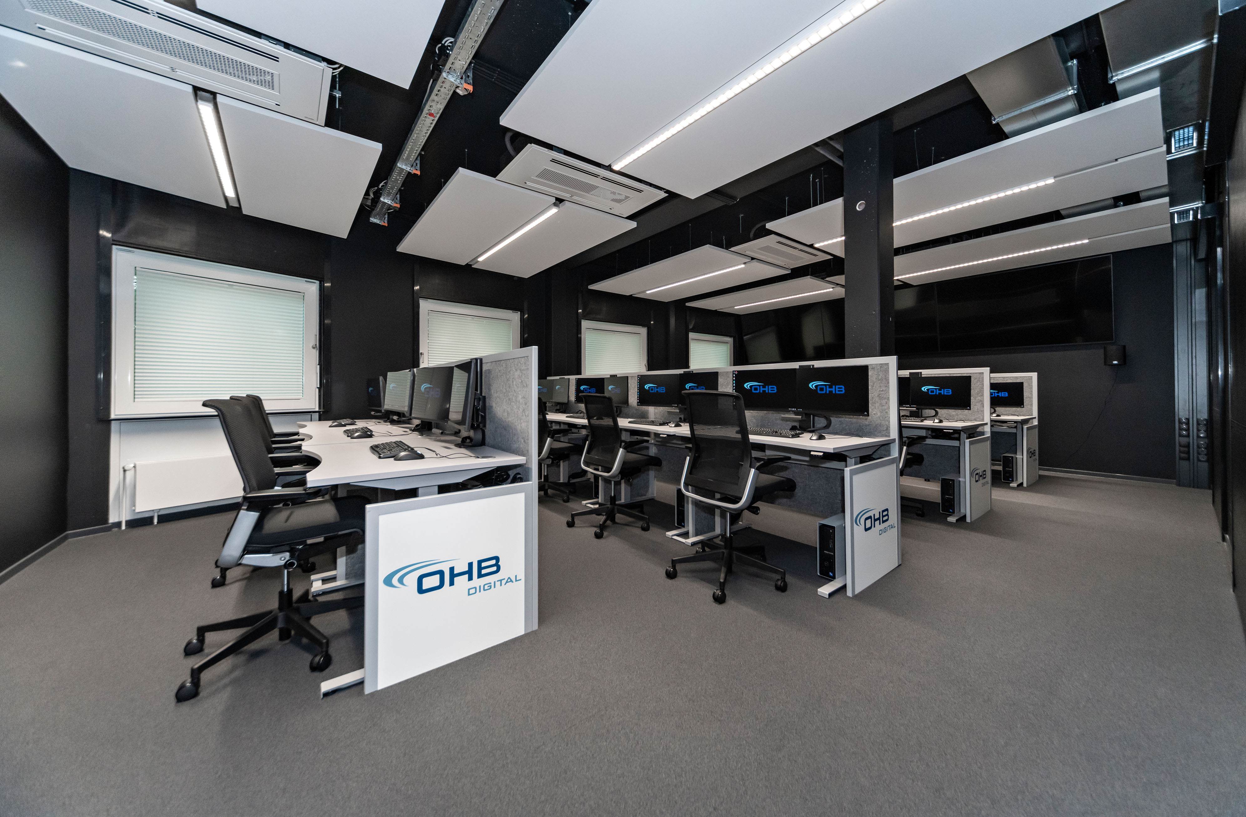 OHB Digital Connect GmbH I lino Schreibtisch, elektrisch höhenverstellbar | Tischanschlußfelder in Sonderausführung | gepulverte Tischplatten in Sonderform | Akustikblenden & Sichtschutz aus Polyestervlies | sano Drehstuhl