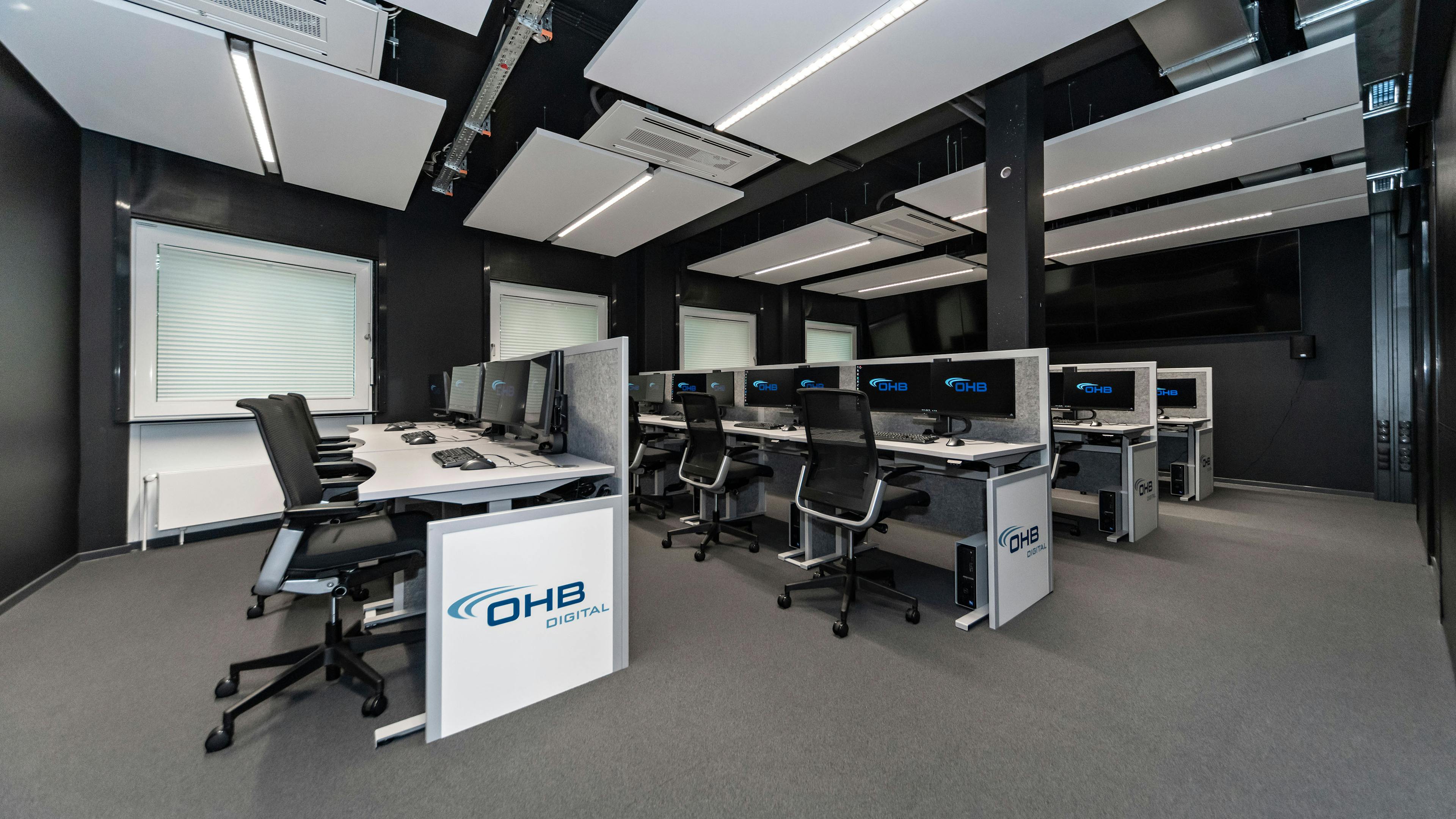 OHB Digital Connect GmbH I lino Schreibtisch, elektrisch höhenverstellbar | Tischanschlußfelder in Sonderausführung | gepulverte Tischplatten in Sonderform | Akustikblenden & Sichtschutz aus Polyestervlies | sano Drehstuhl