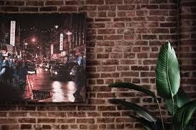 Image of a framed photo of NYC against a red brick wall 