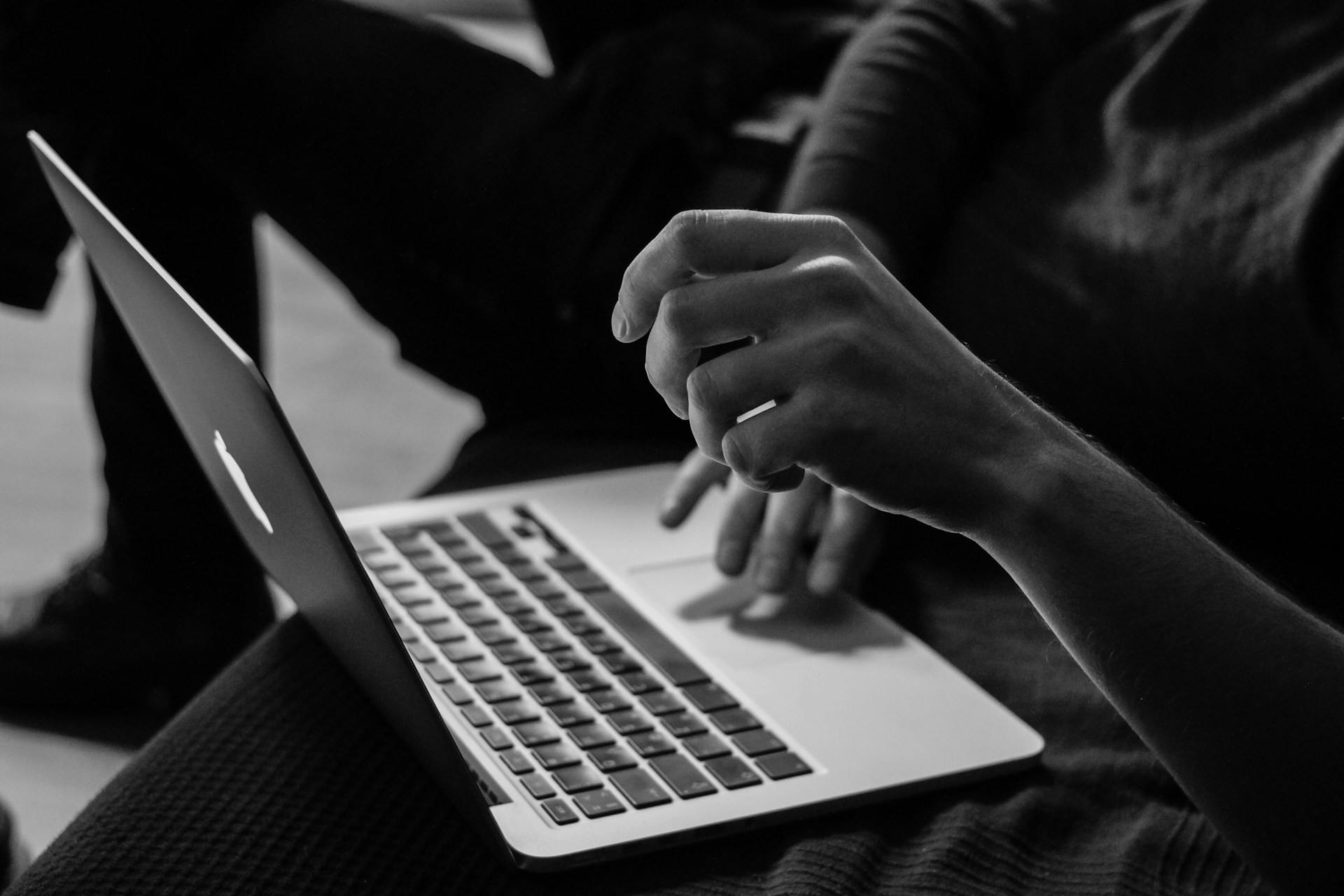 Black and white photo of someone typing on a laptop