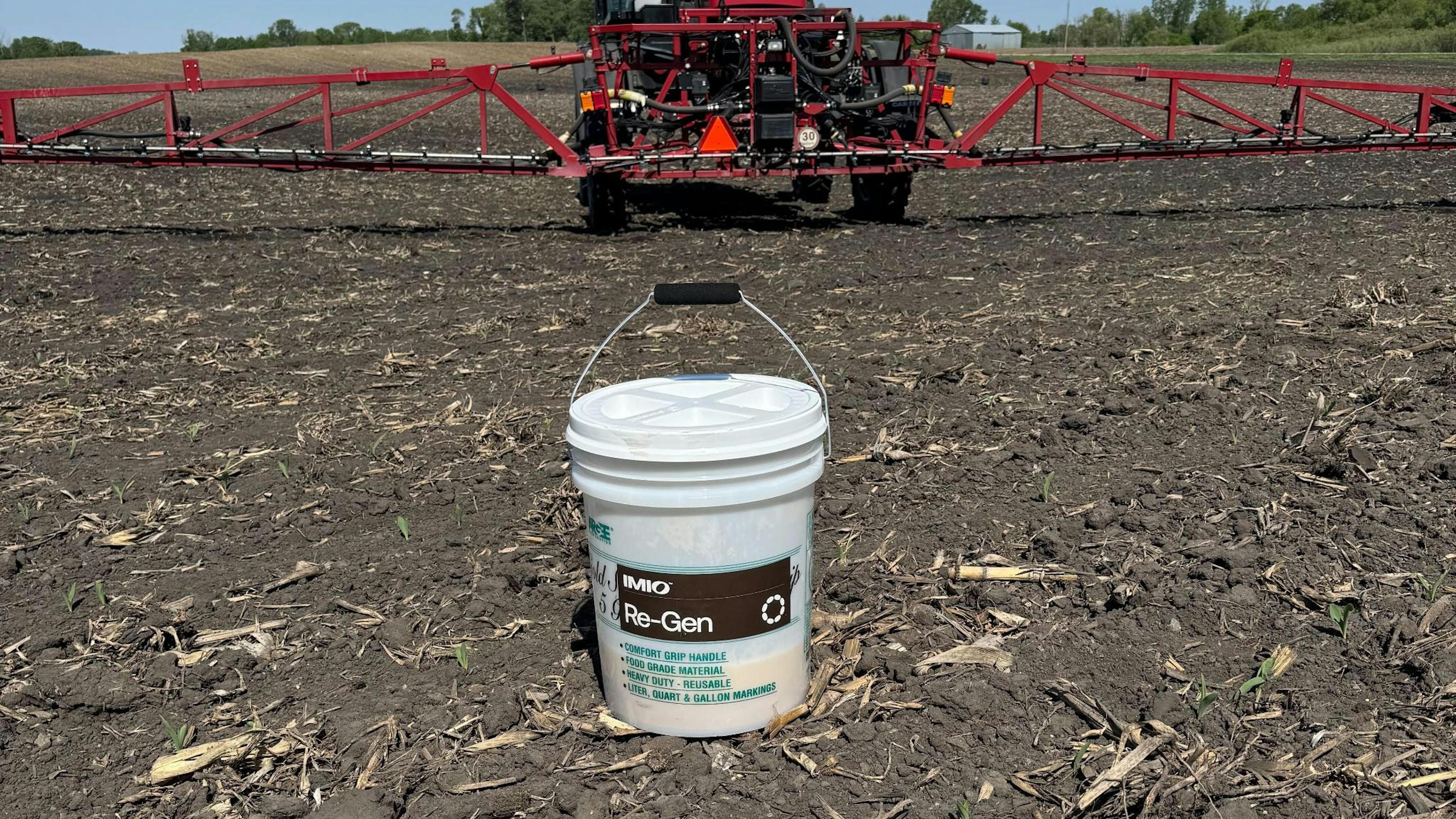 A bucket of Re-Gen stands ready to be used in a field of residue.