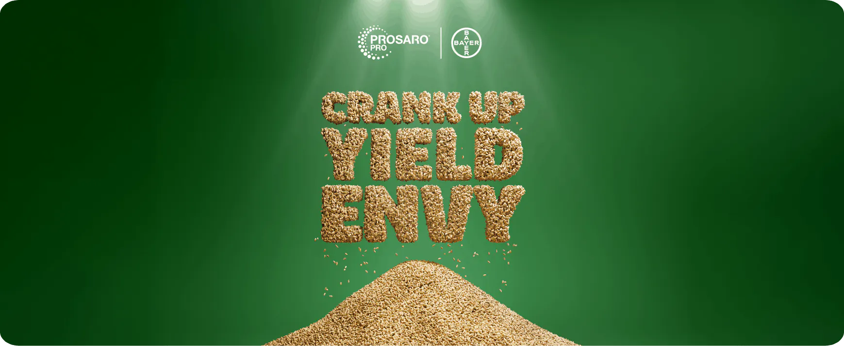 The phrase 'CRANK UP YIELD ENVY' formed with wheat seeds, above a pile of wheat seeds against a green background.