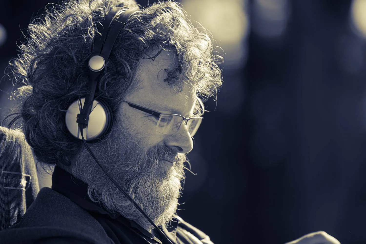 Sound Engineer Alex Fiennes with headphones in black and white. Photo by by Jason Russell