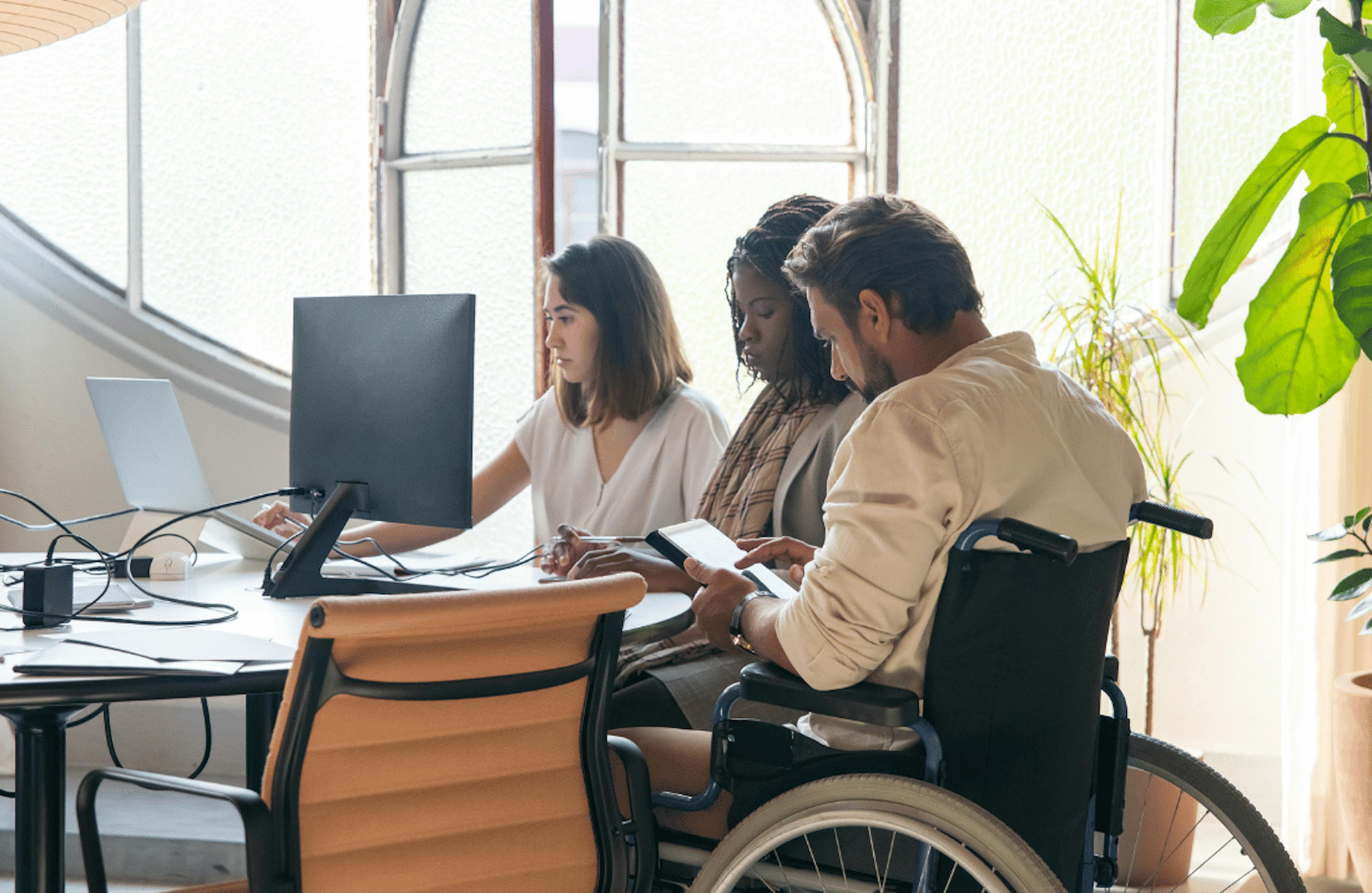 Agency team gather round computer in office