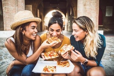 Three women sharing pizza