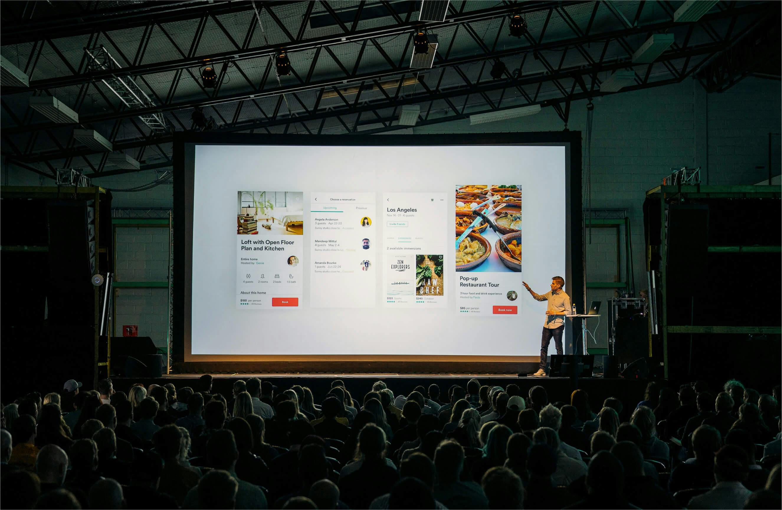 Person presenting live on stage at a corporate event.