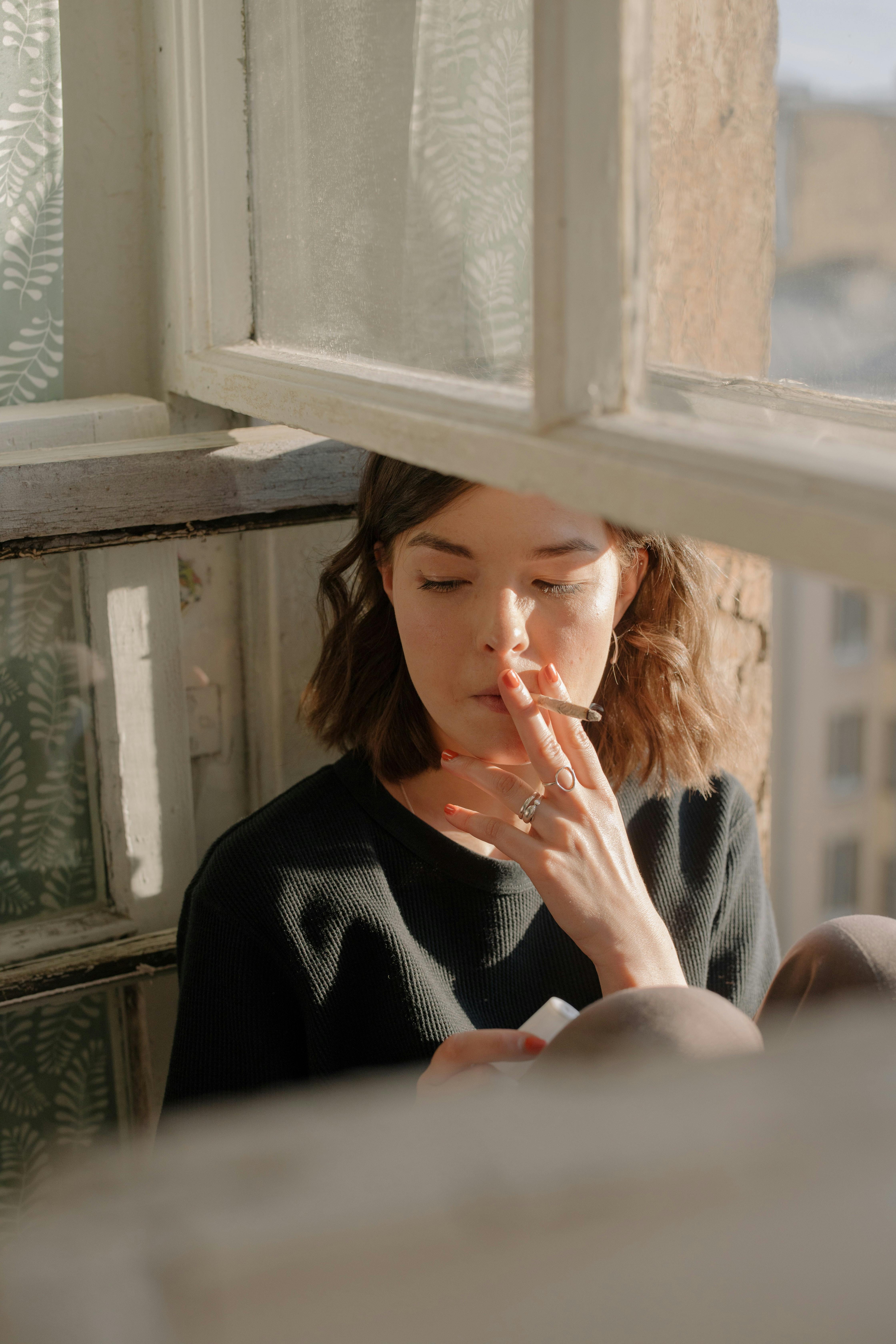 Woman smoking a joint in the window.