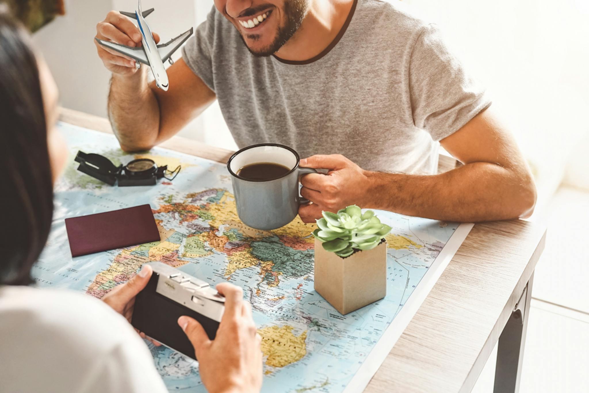 A playful couple planning their next trip over coffee.