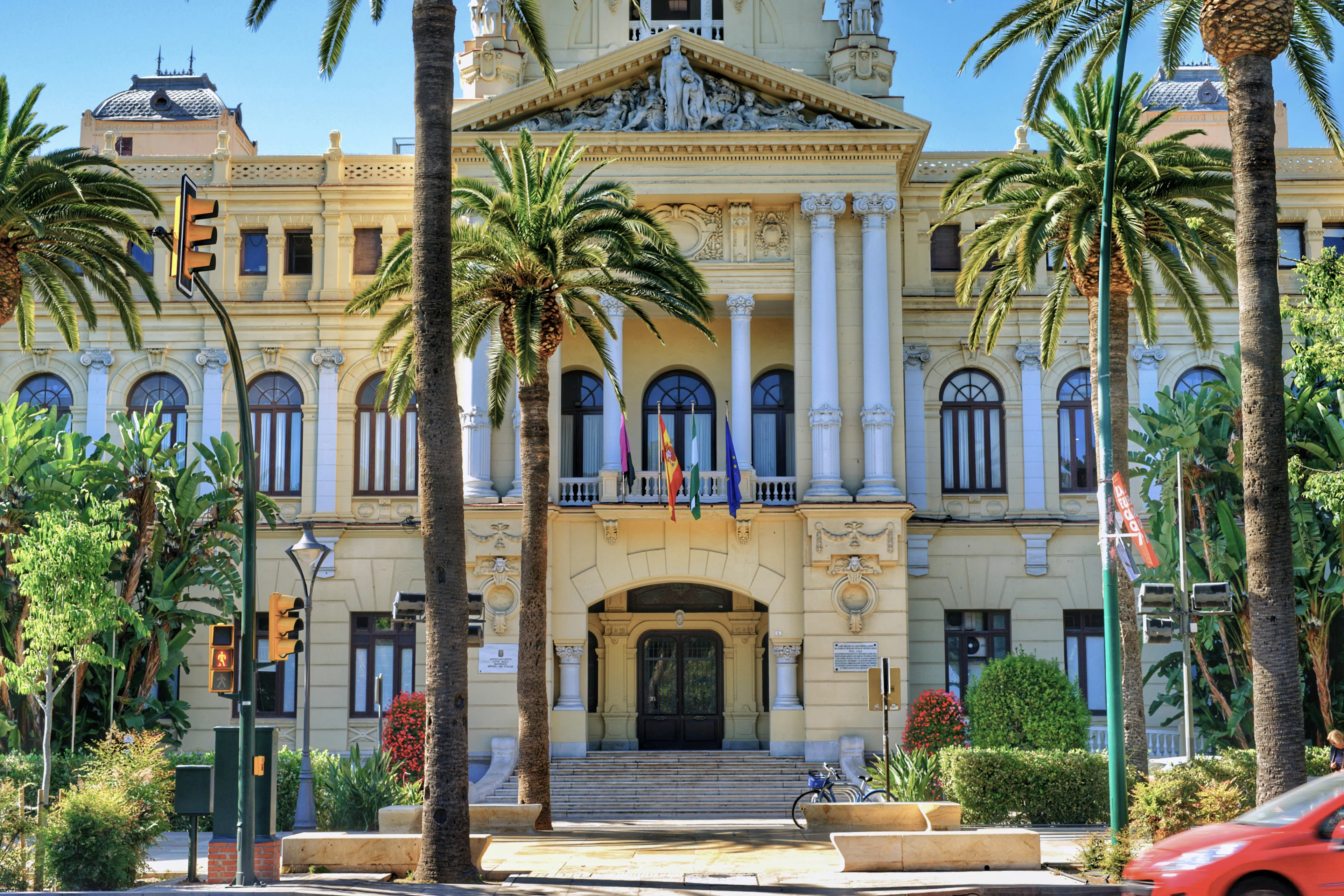 Historic building framed by palm trees, showcasing Málaga’s elegant architecture and Mediterranean charm.