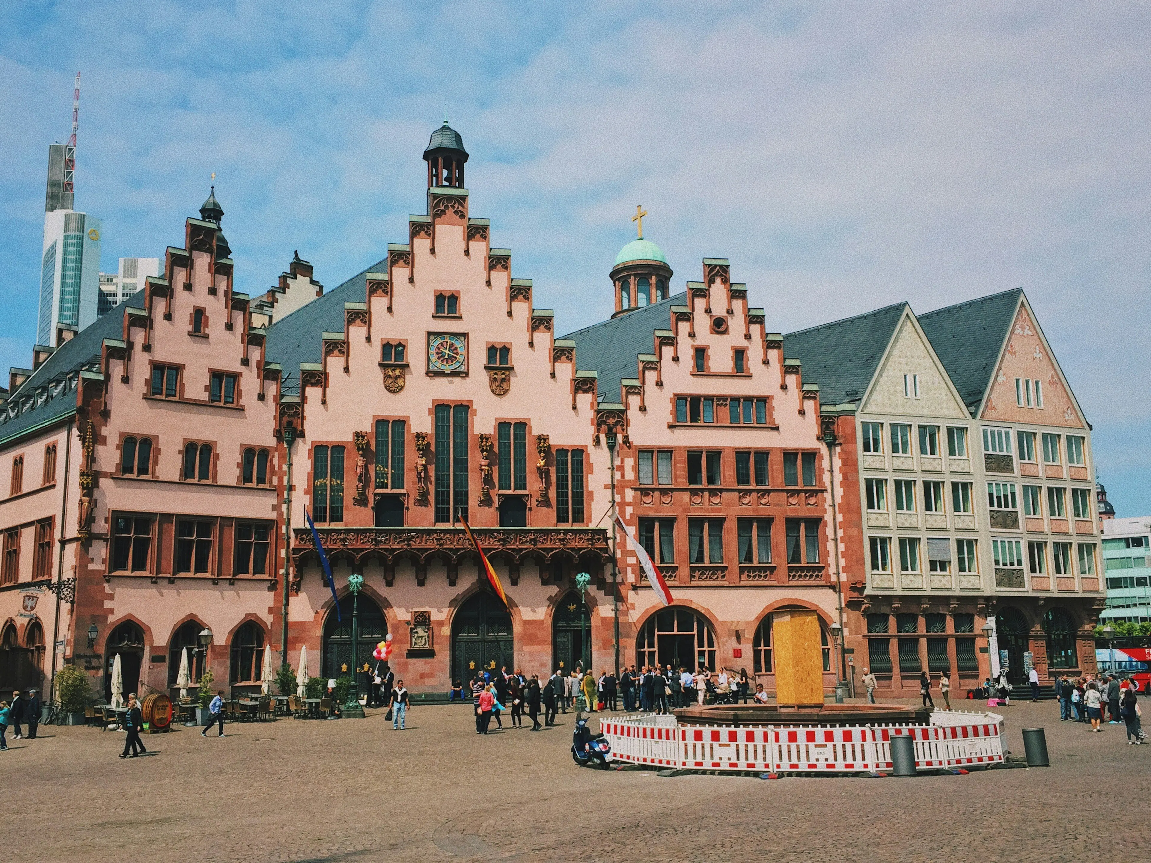 Historic Frankfurt building with stepped gables, decorative stonework, and pedestrians in the plaza.