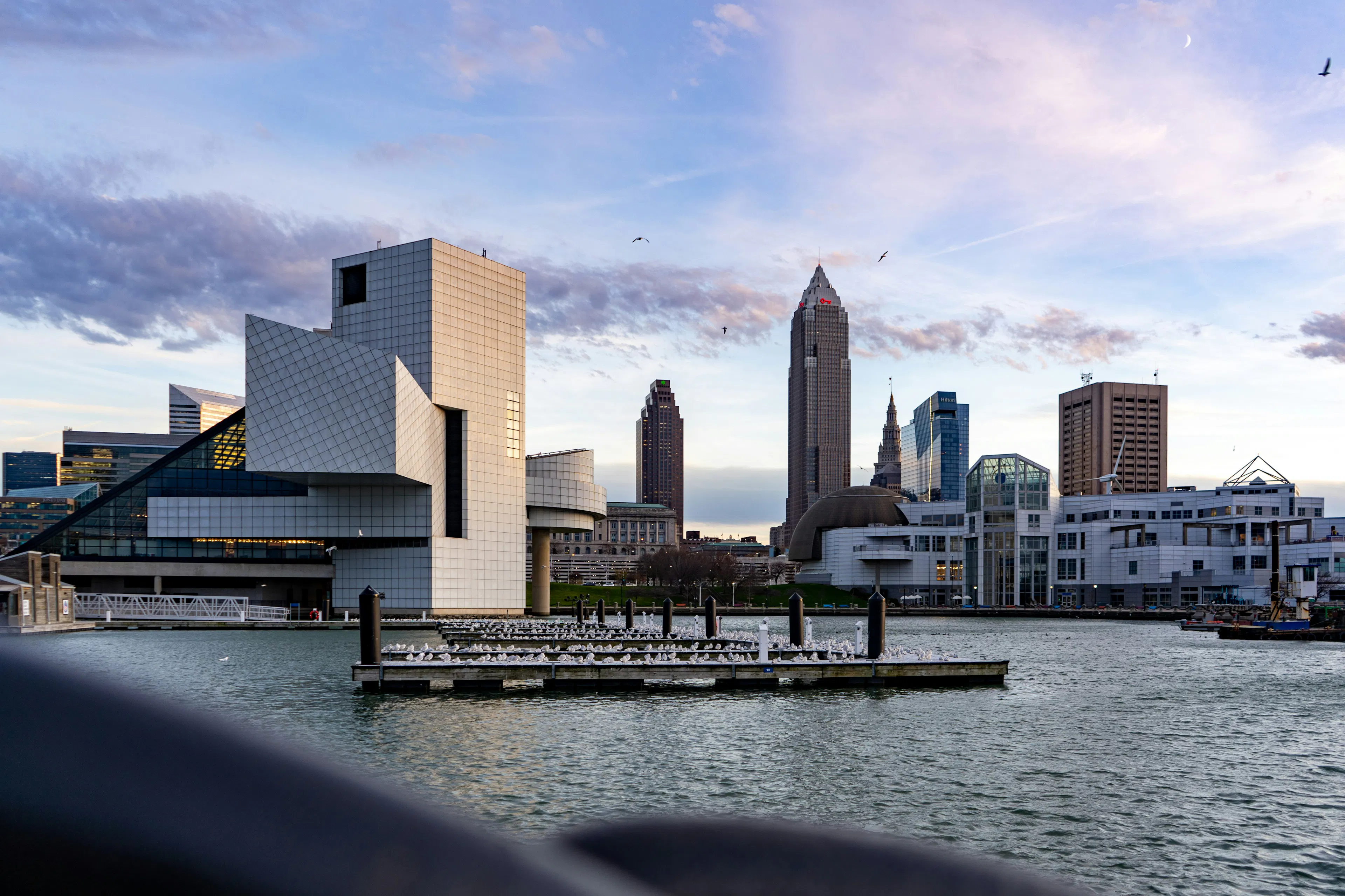 Cleveland waterfront with the Rock and Roll Hall of Fame, downtown skyline, and Lake Erie at dusk.