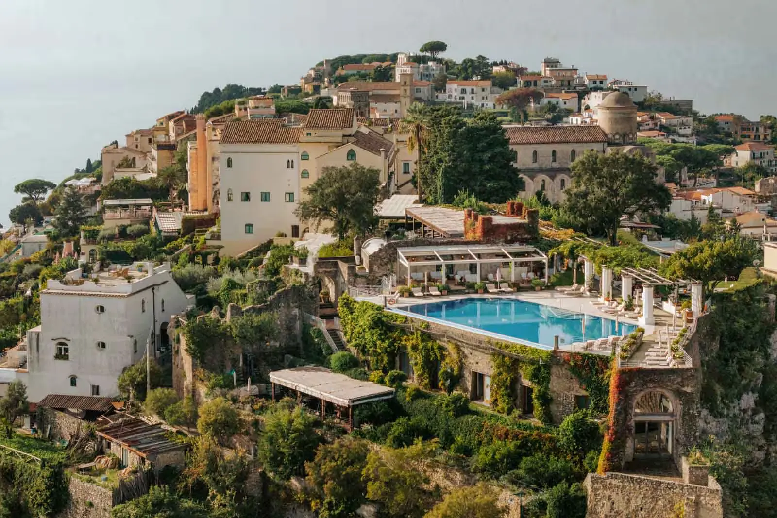 Hillside luxury resort featuring a swimming pool and panoramic coastal views.