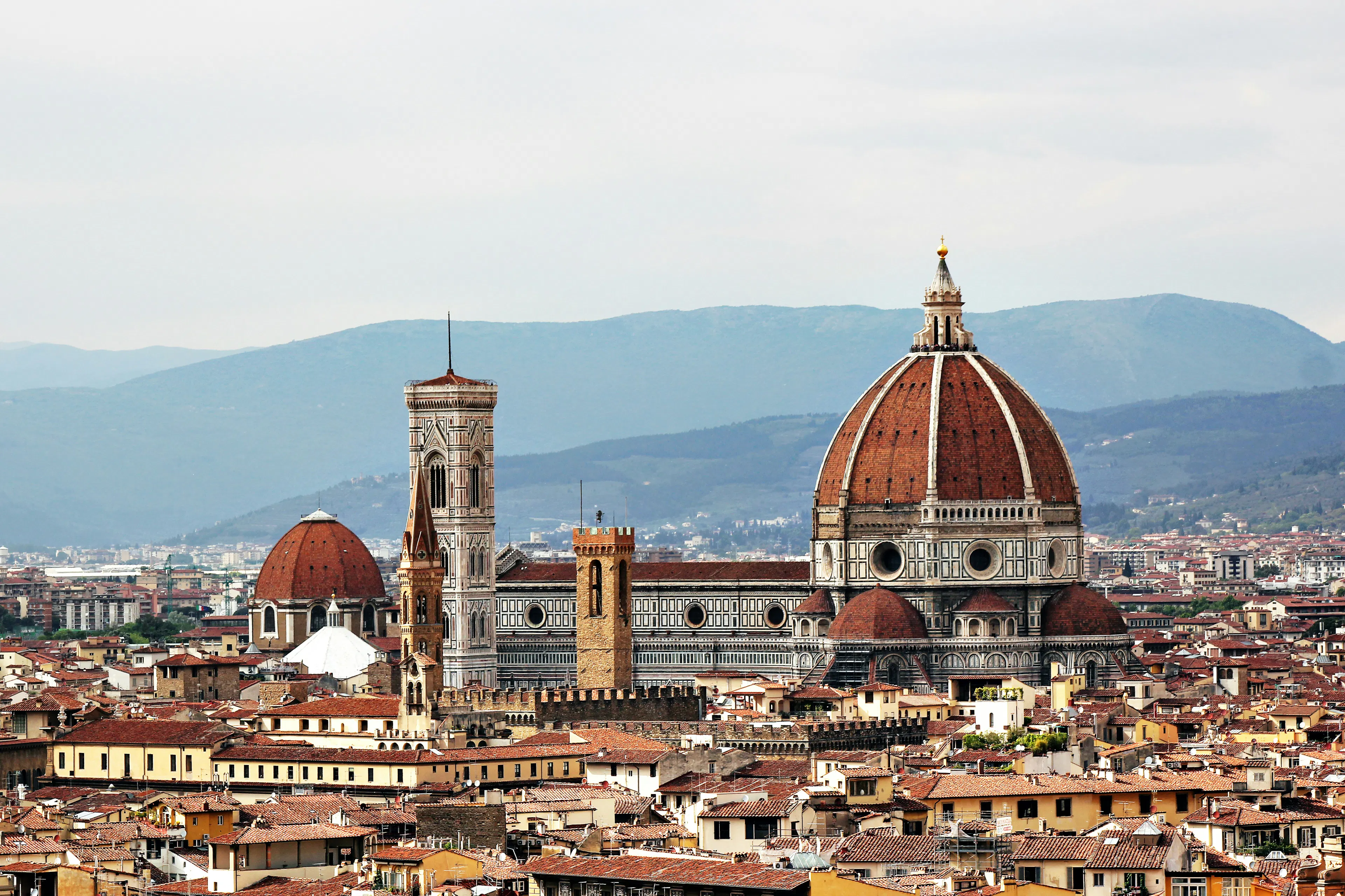 Florence skyline featuring the Cathedral of Santa Maria del Fiore with its red dome and bell tower.