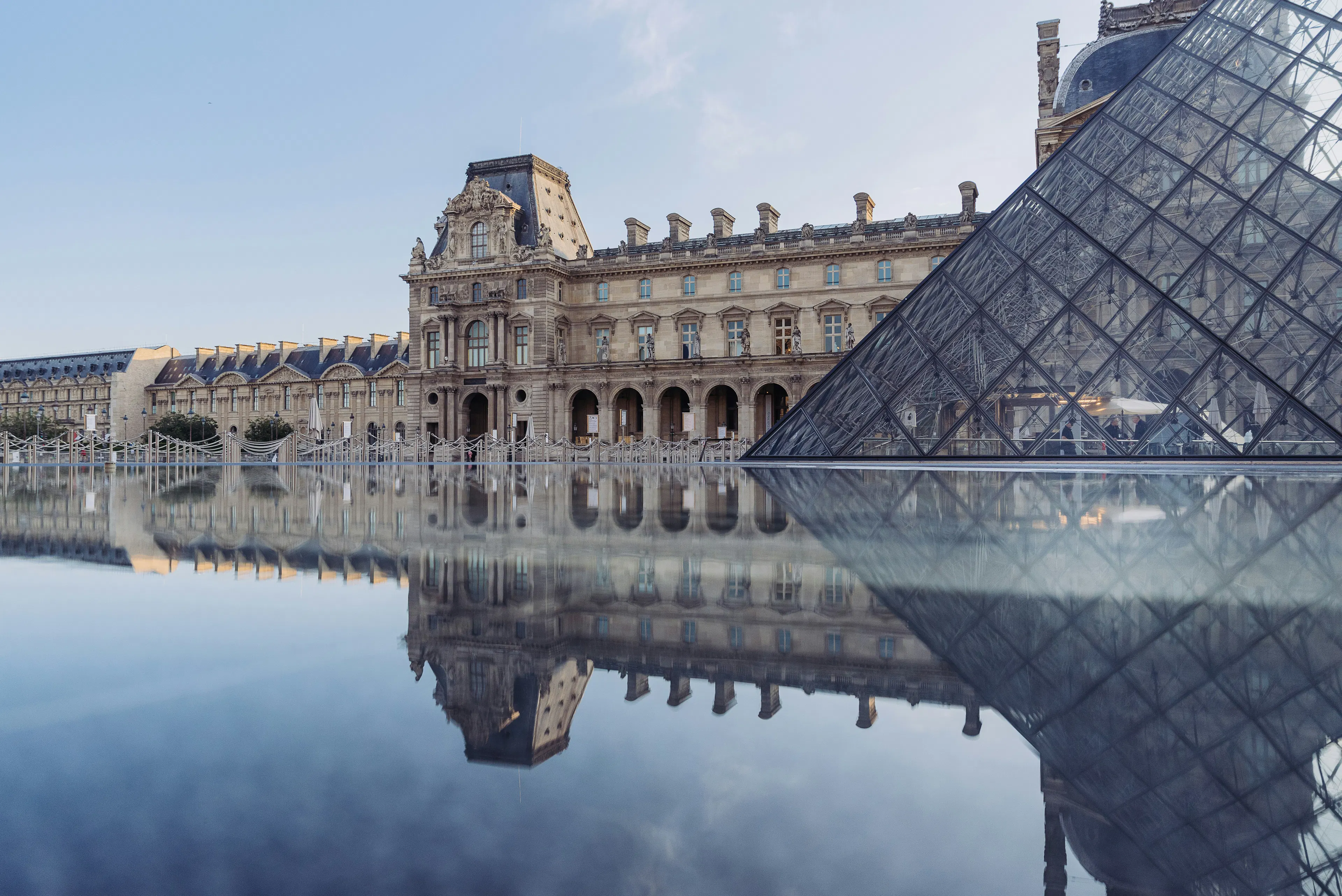Louvre Museum and glass pyramid reflected in the water
