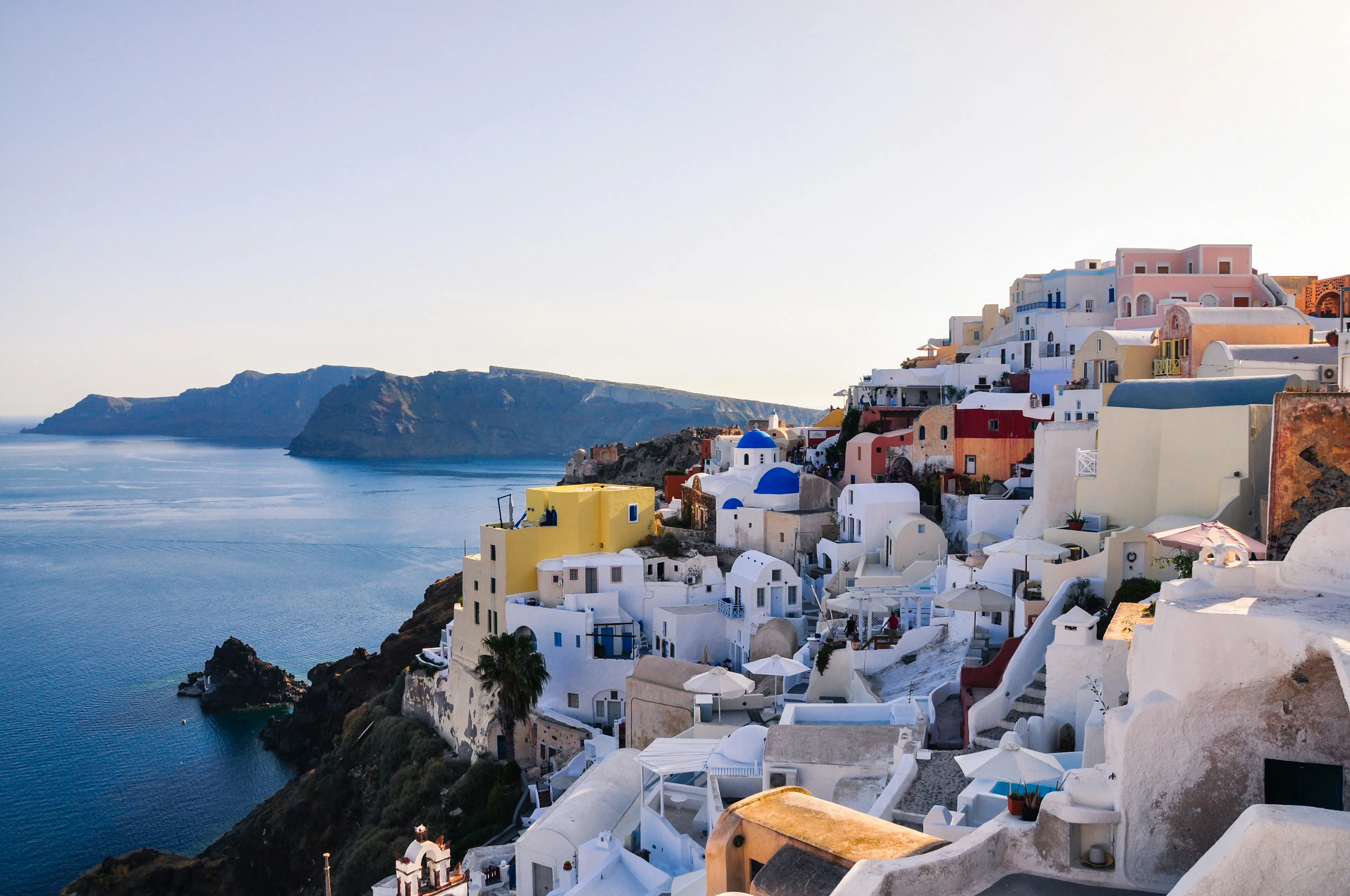 Whitewashed hillside buildings overlooking the Aegean Sea, showcasing Mykonos’ iconic Cycladic architecture and coastal views.