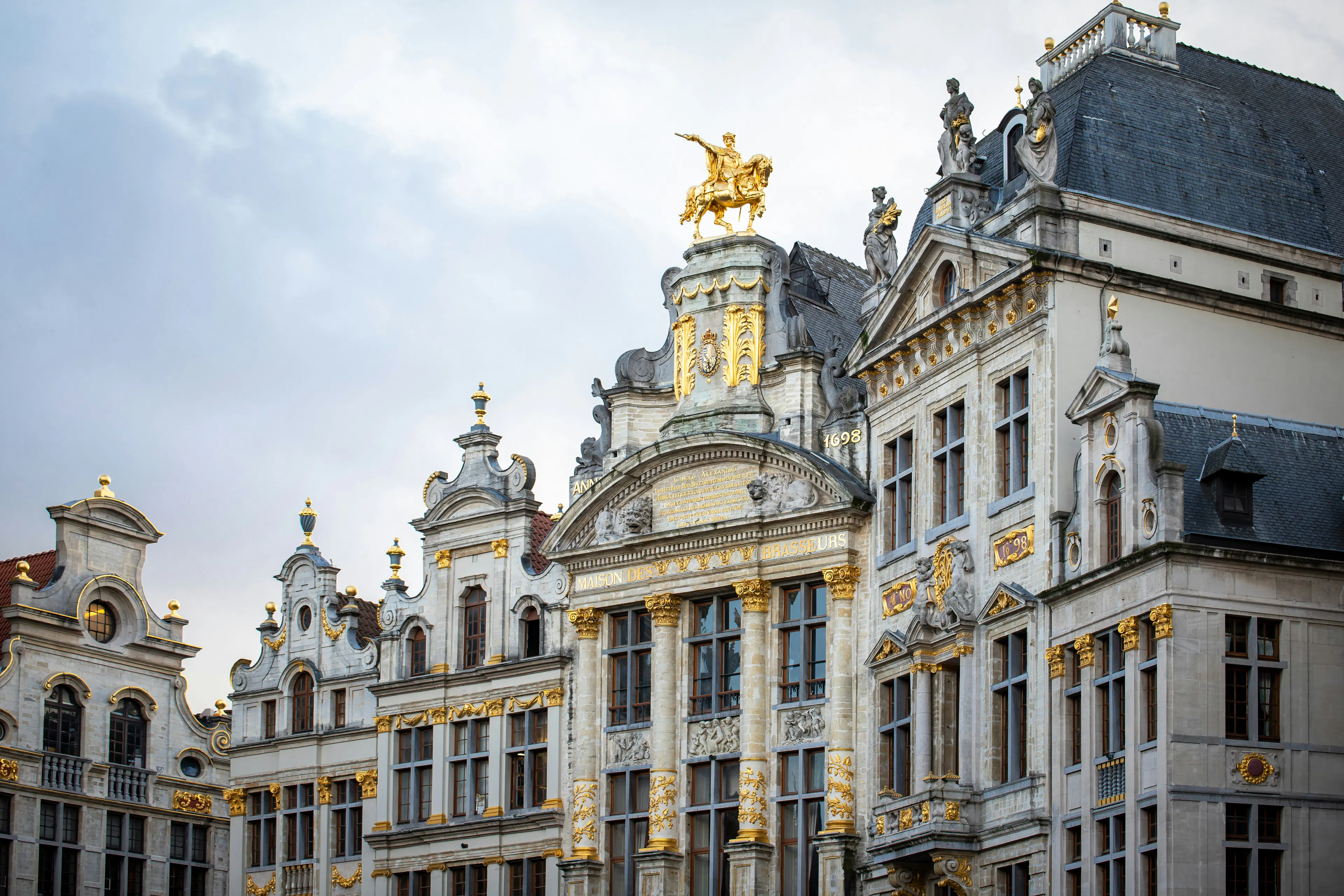 Ornate historic buildings in Brussels with gold trim, statues, and decorative stone facades.