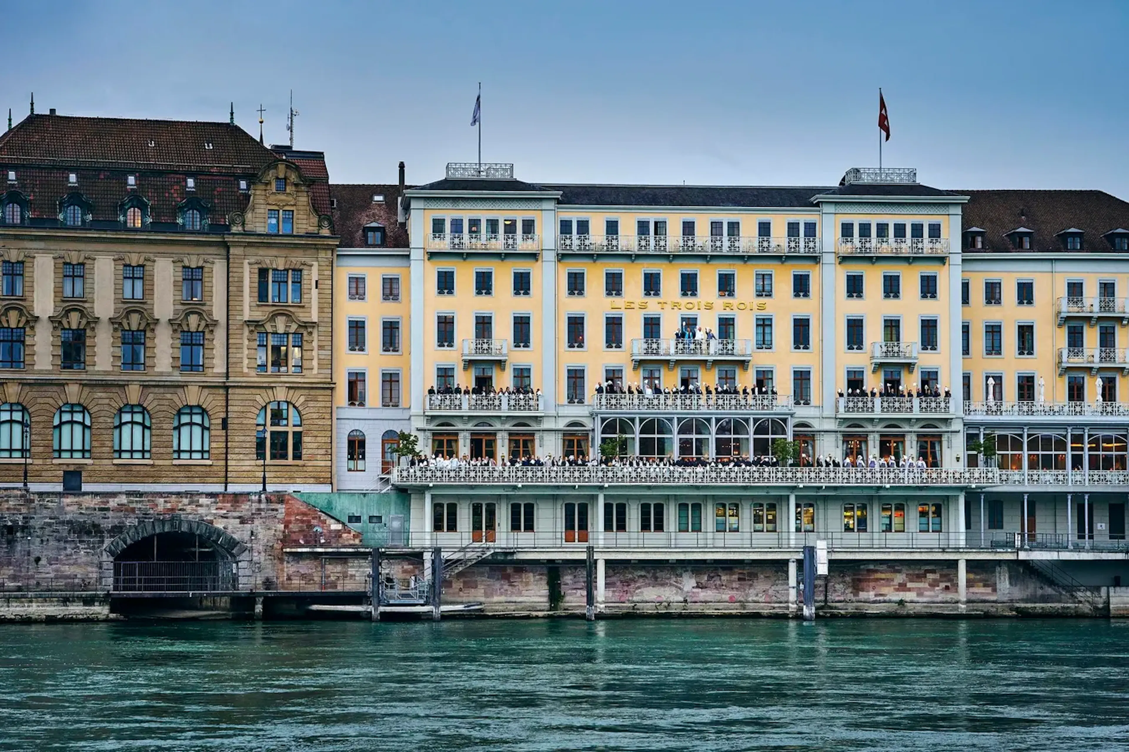 Historic waterfront hotel overlooking a river with classic European architecture.