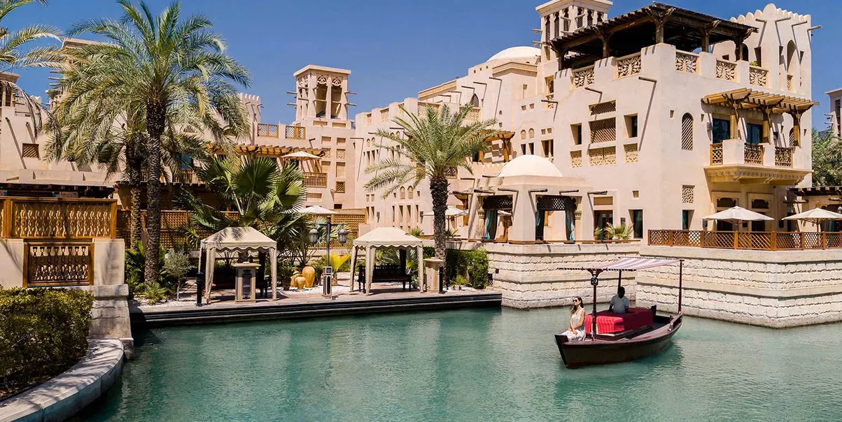 Waterfront resort with traditional architecture and boat on a canal.