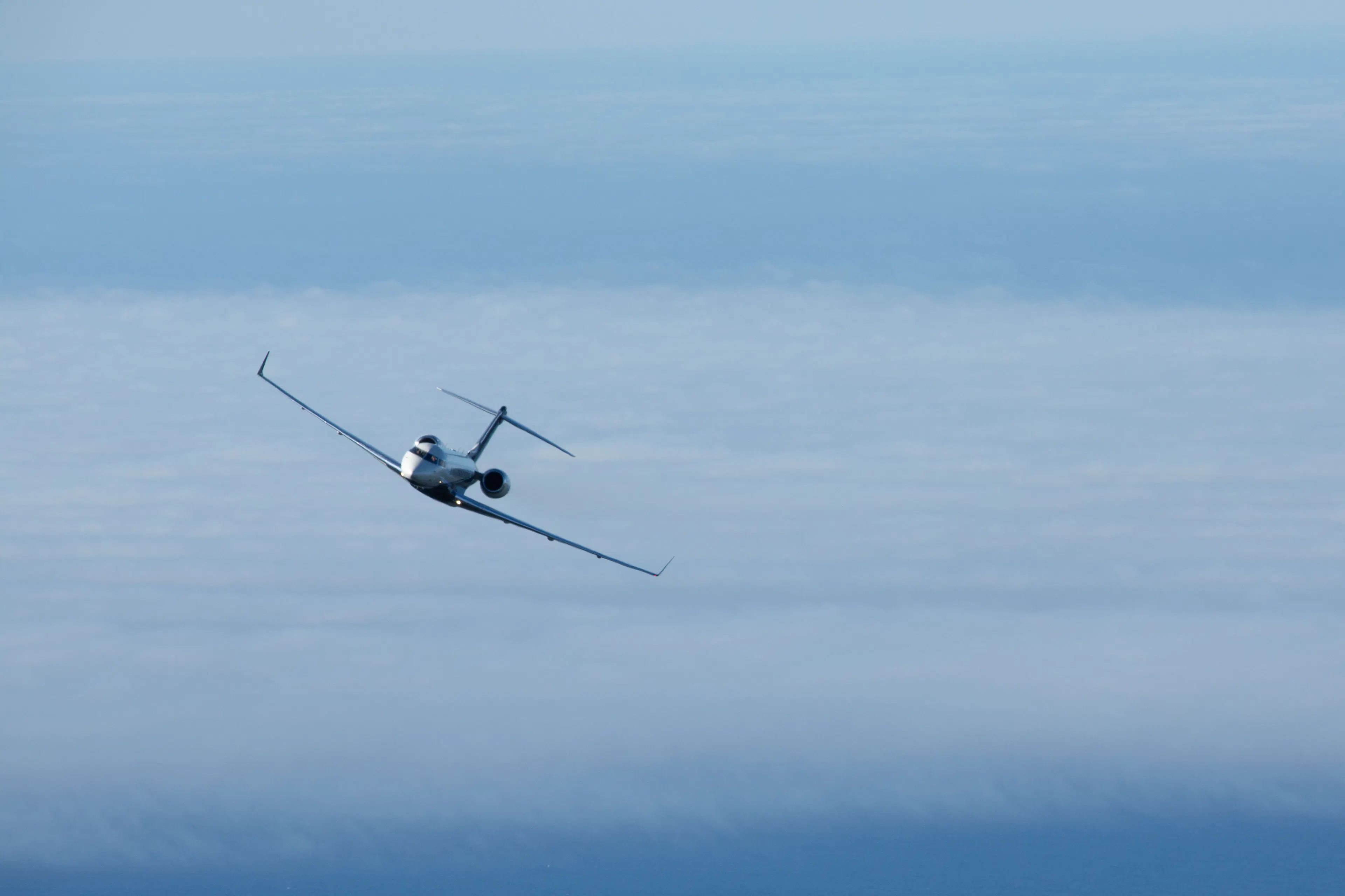 Private jet flying above the clouds