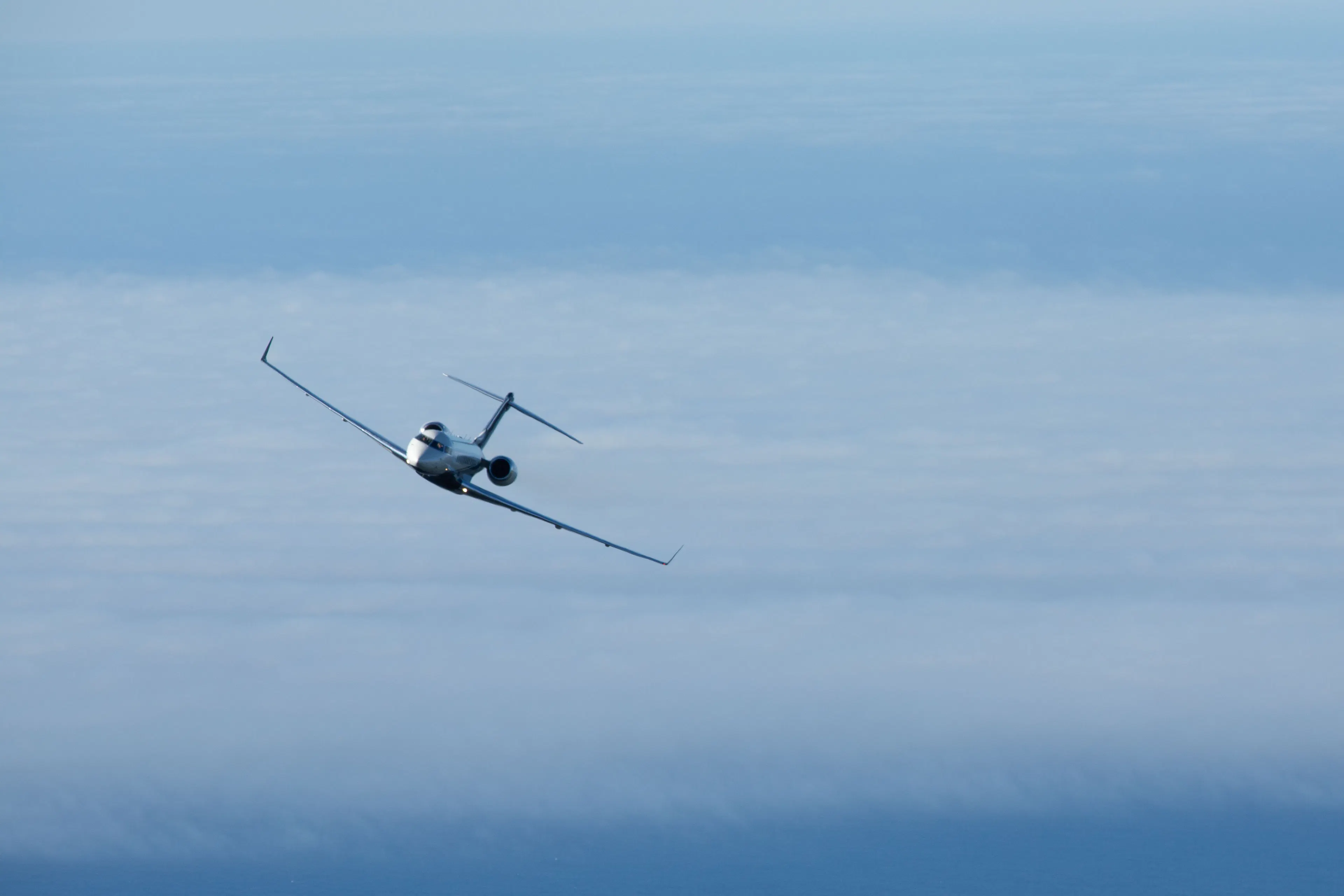 Private jet flying above the clouds