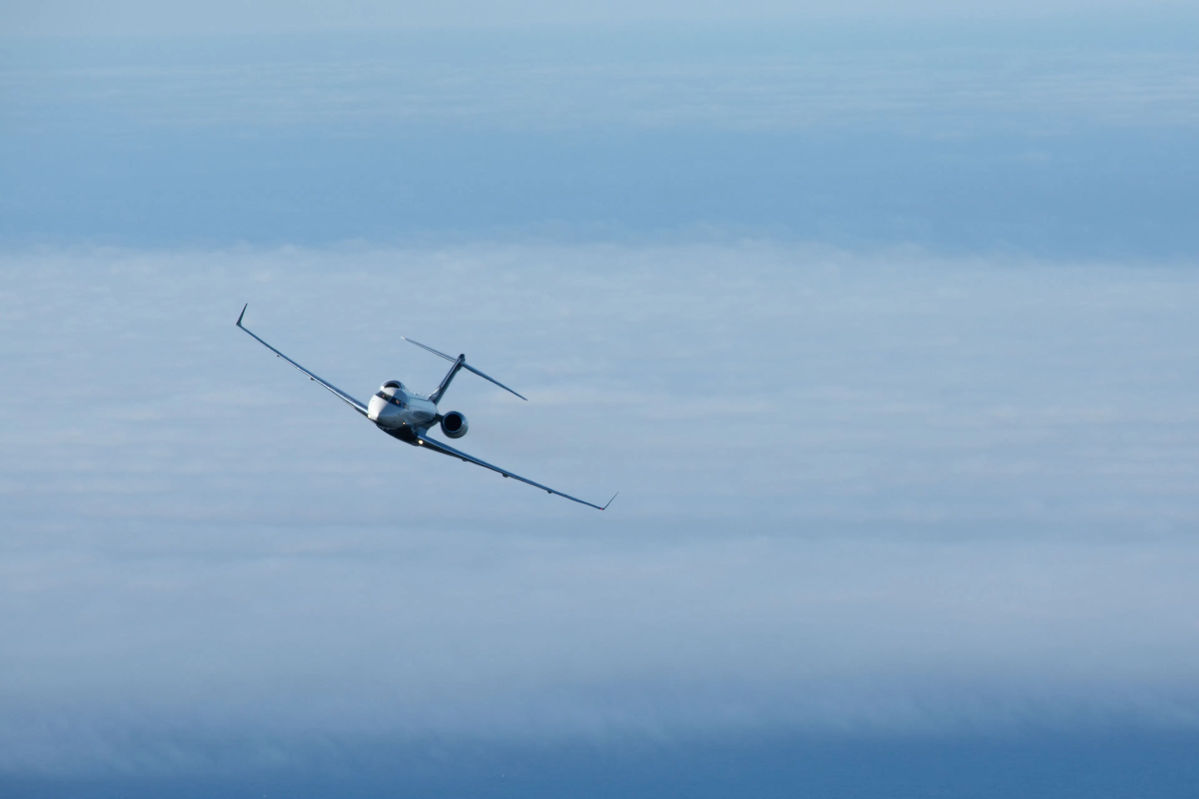 Private jet flying above the clouds