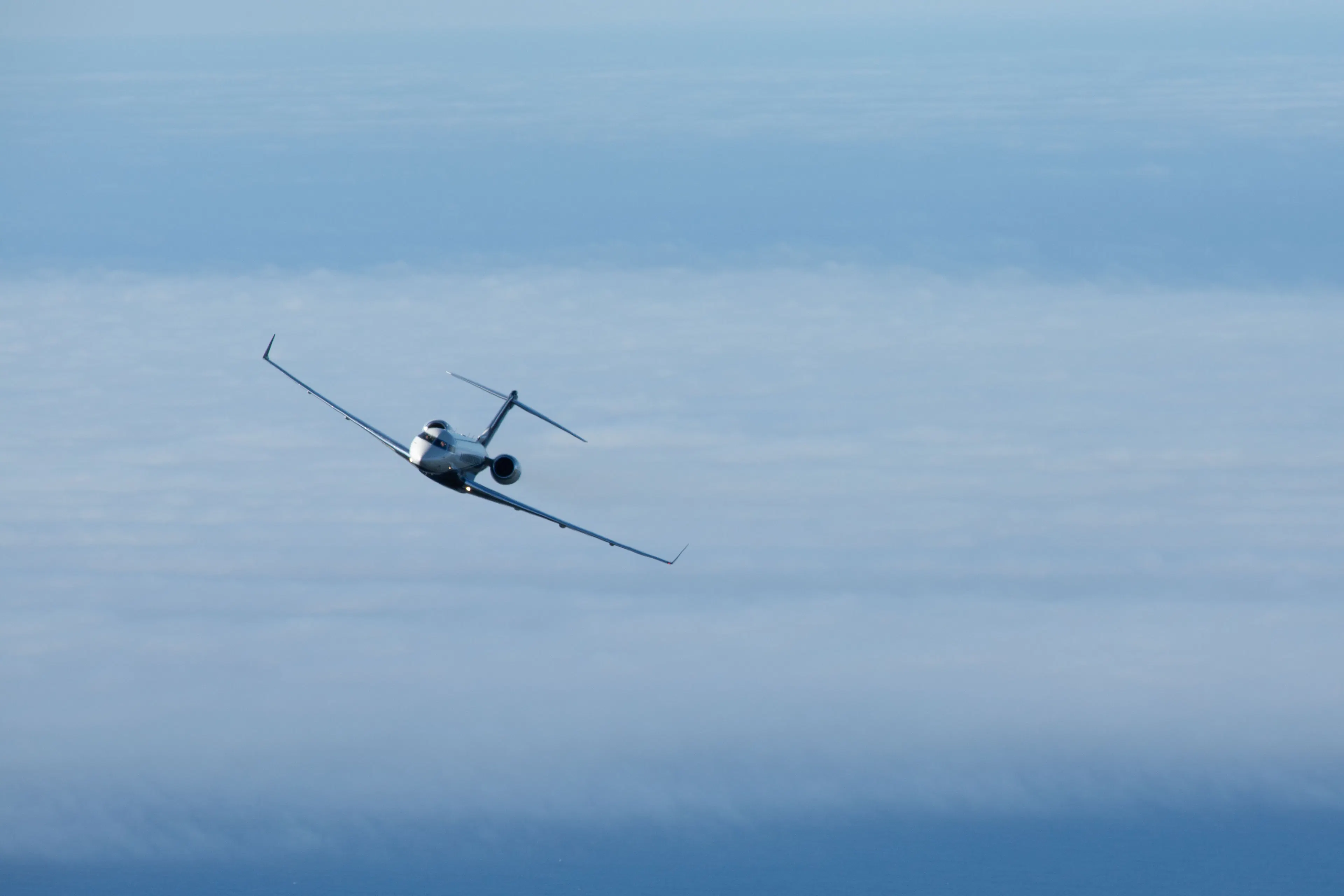 Private jet flying above the clouds