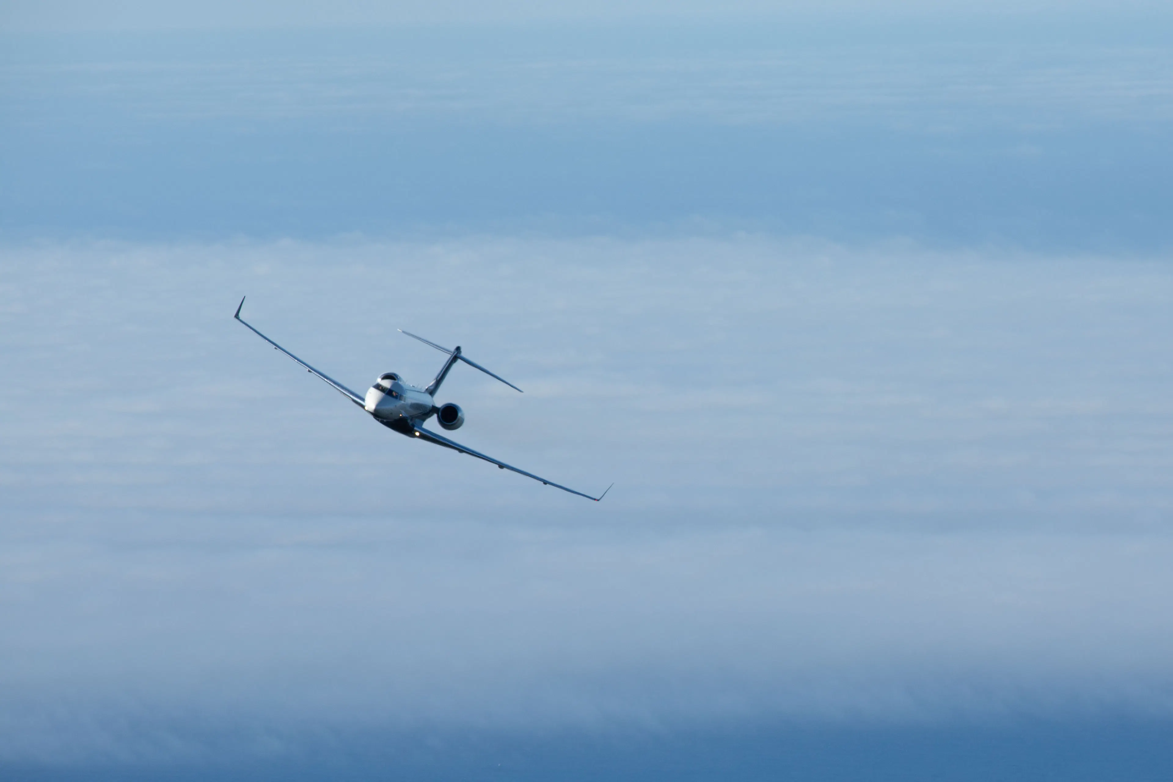 Private jet flying above the clouds