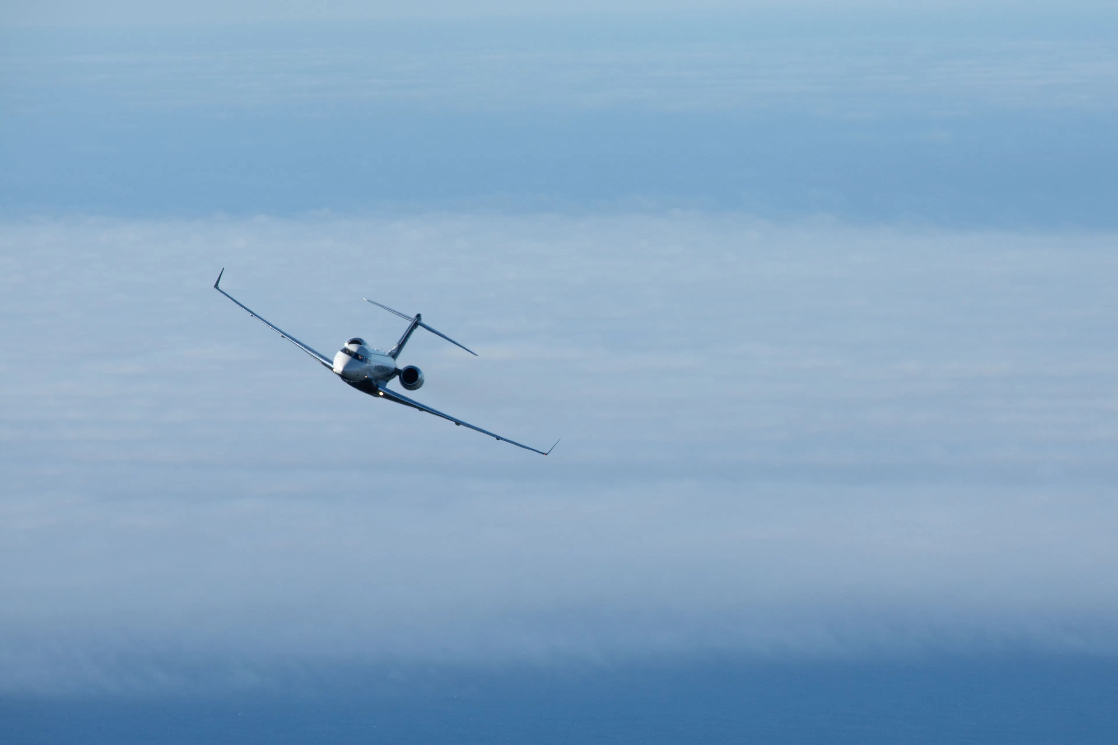 Private jet flying above the clouds