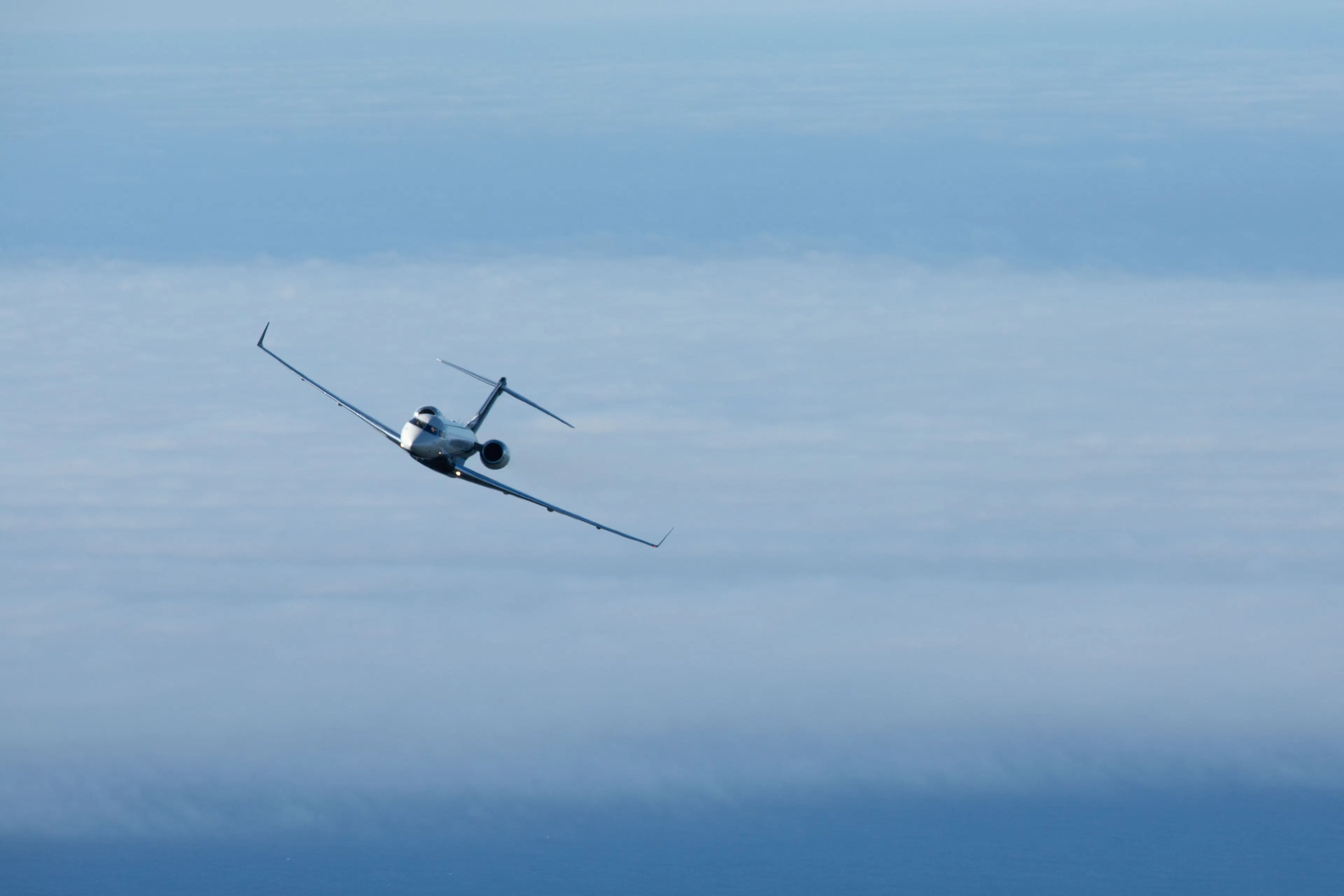 Private jet flying above the clouds