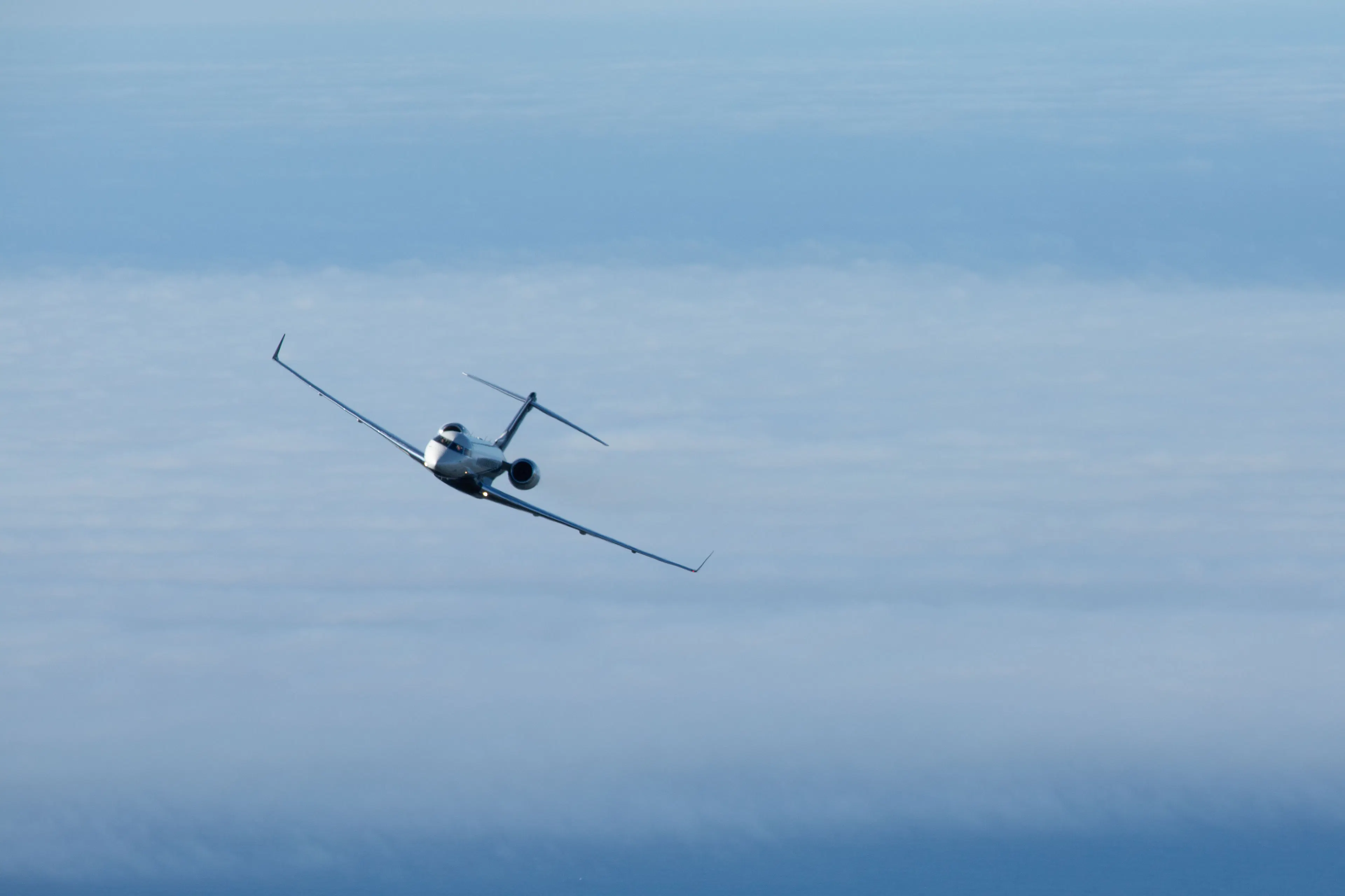 Private jet flying above the clouds
