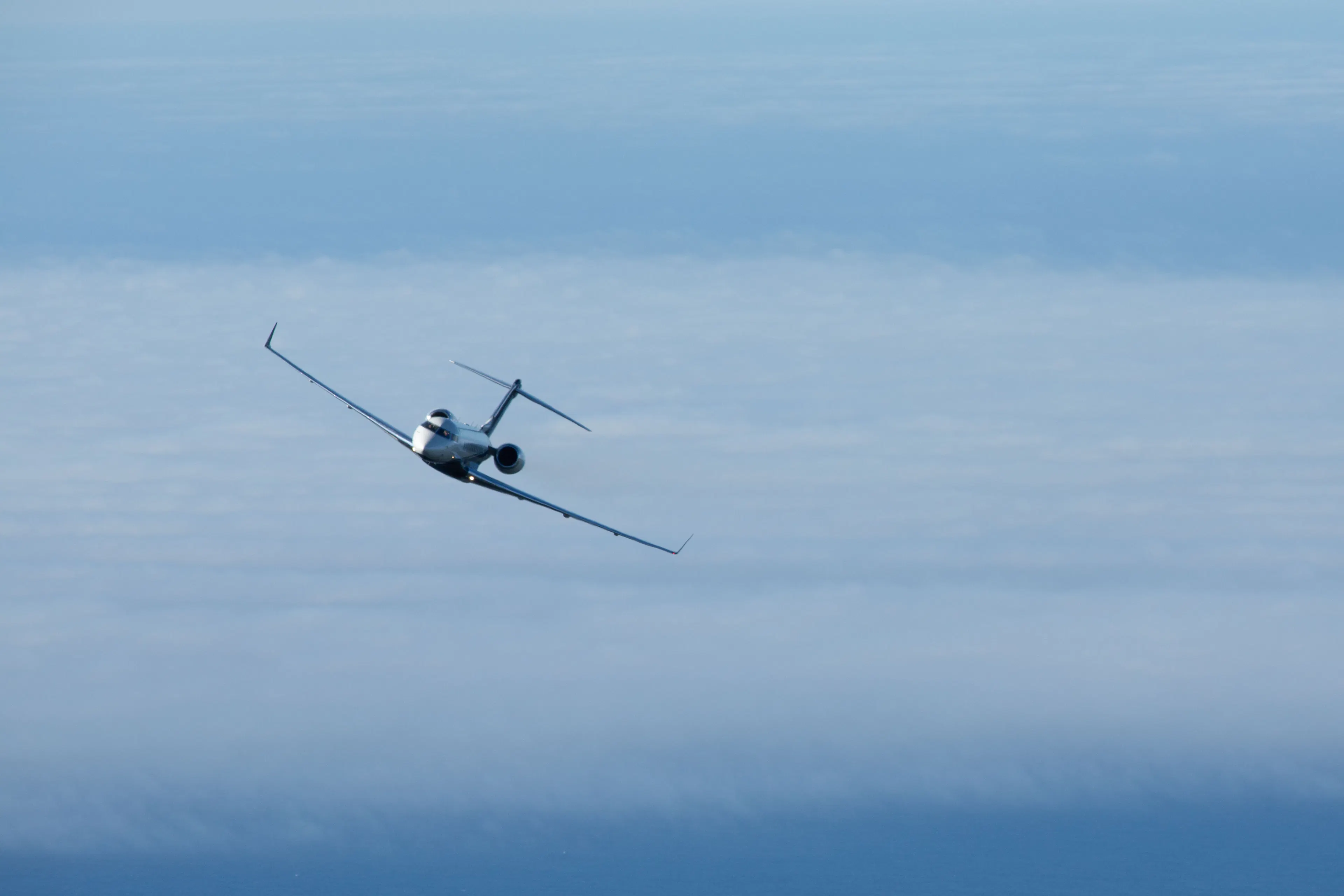 Private jet flying above the clouds