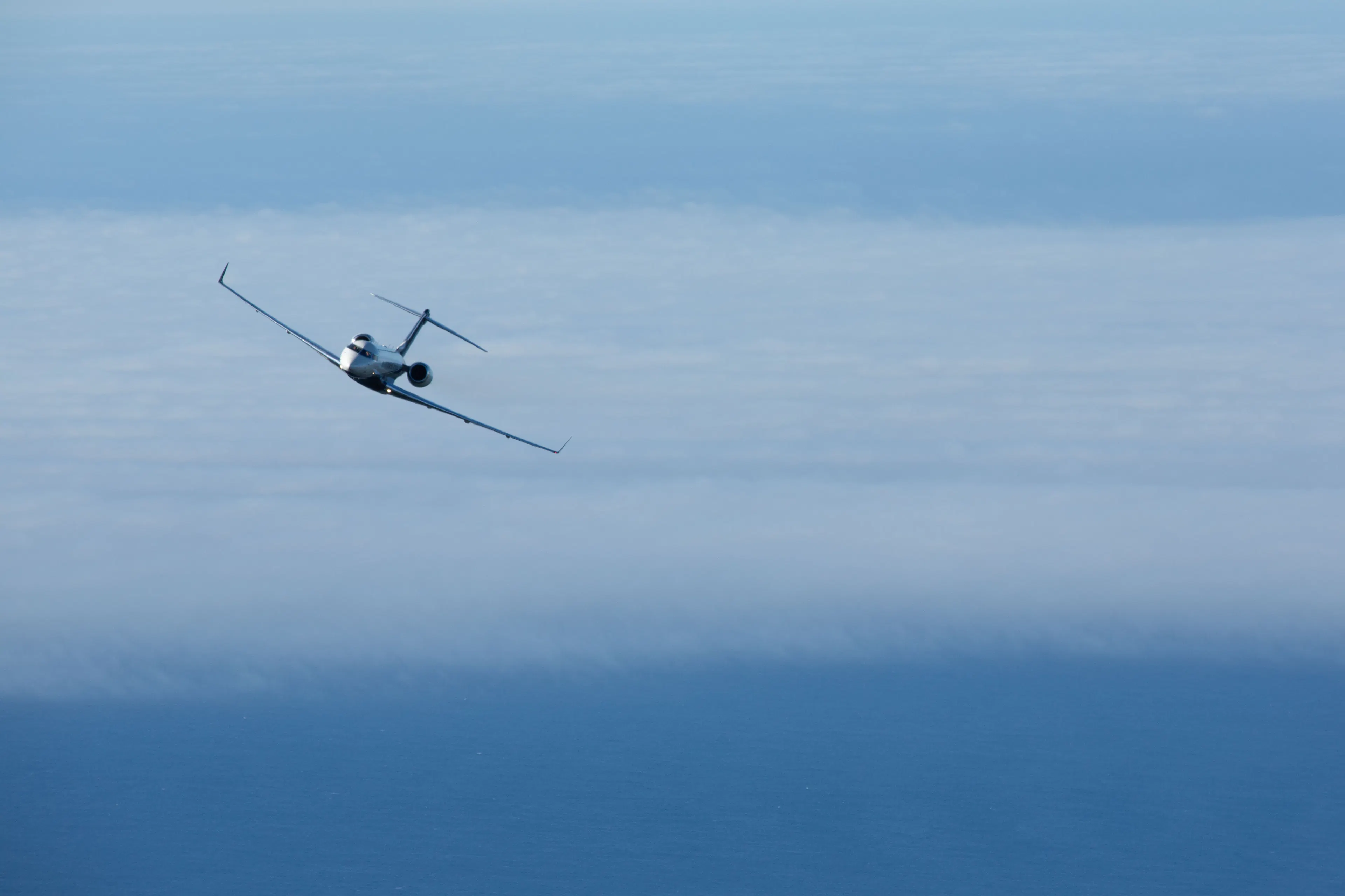 Private jet flying above the clouds