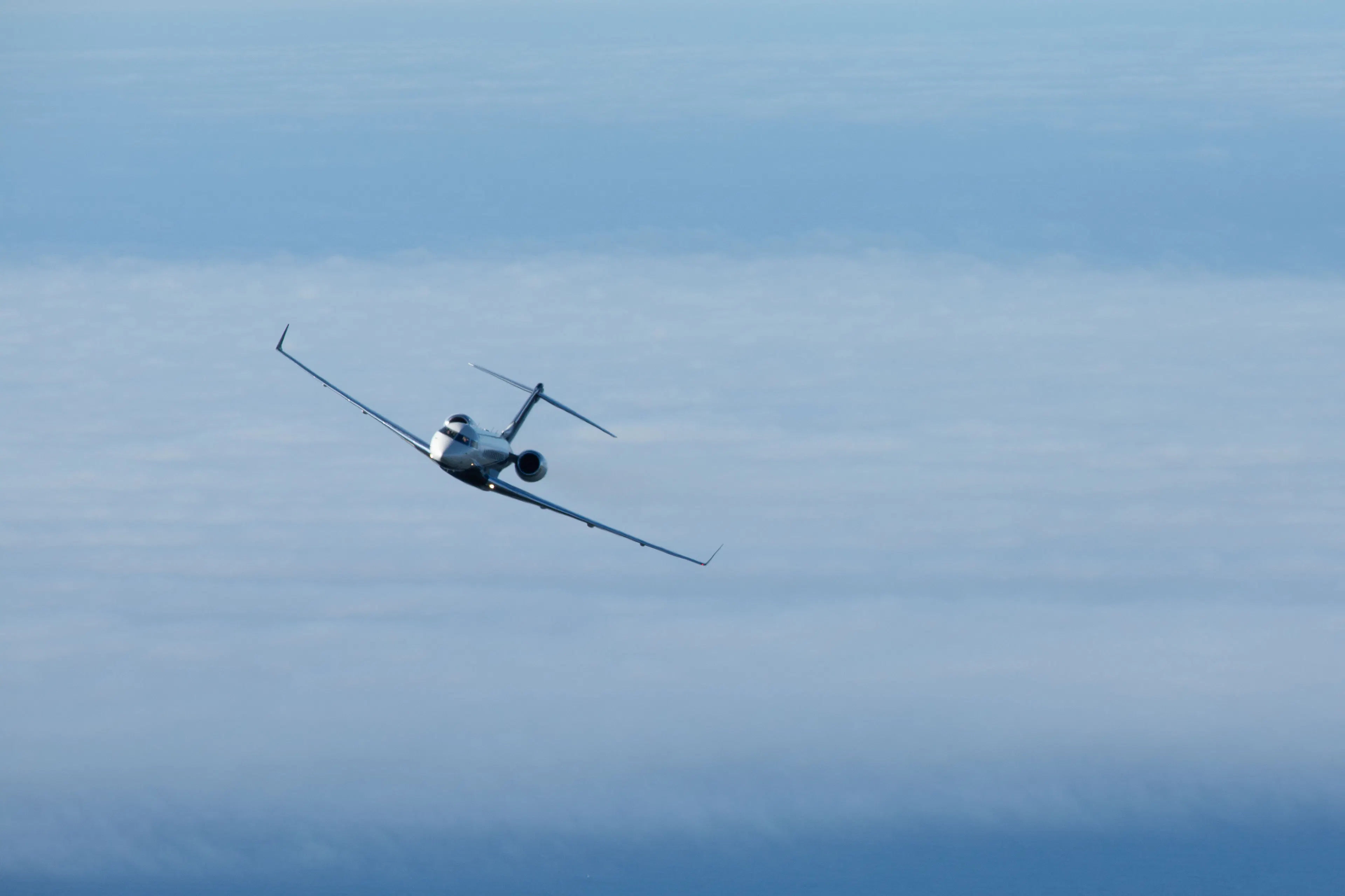 Private jet flying above the clouds